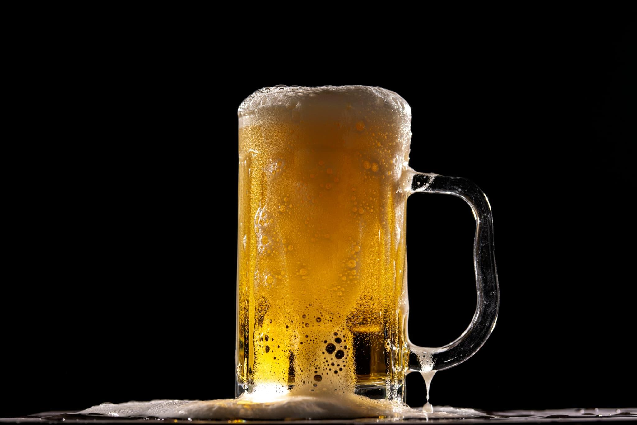 泡があふれる黄金色のビールが入ったジョッキ