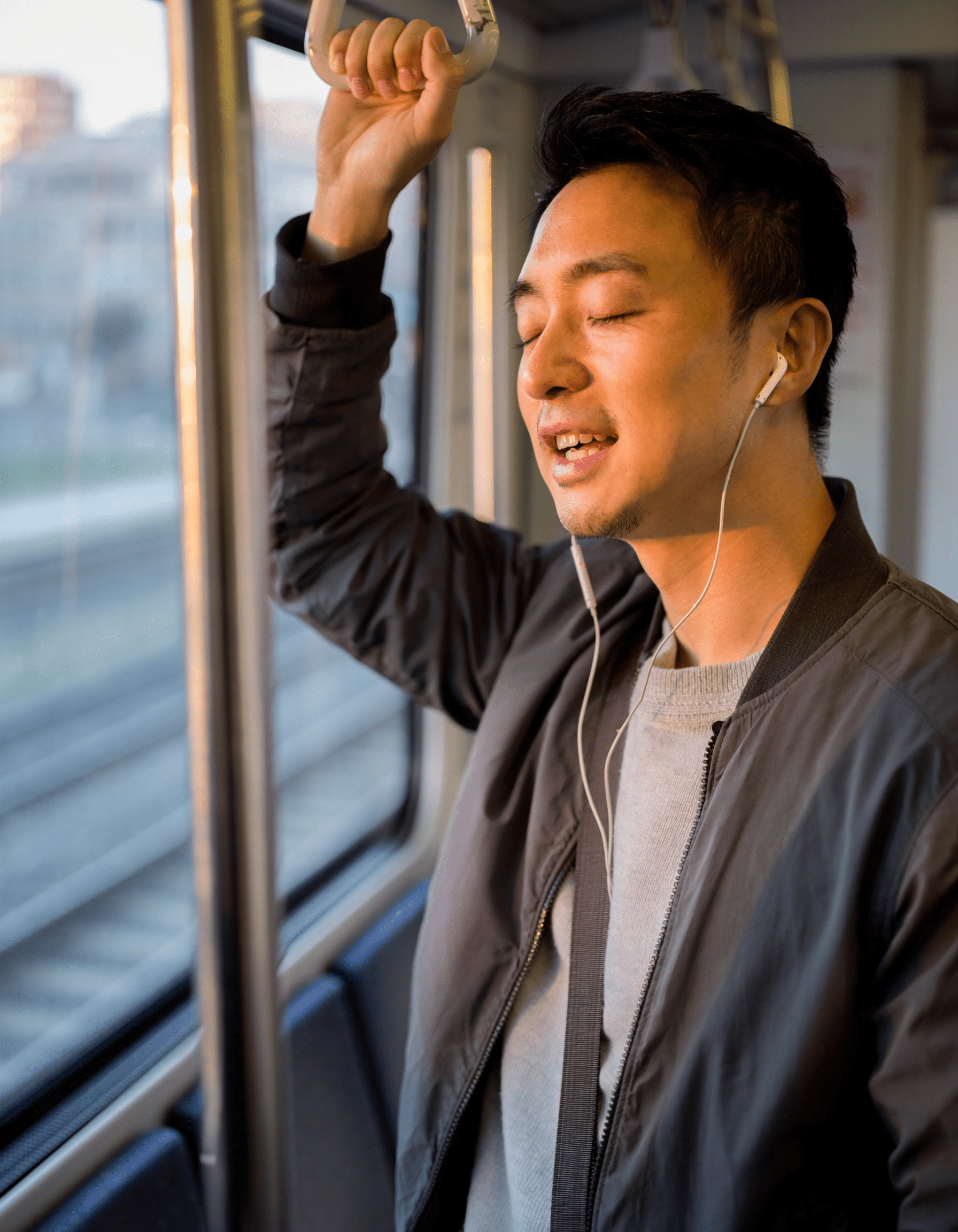 通勤電車で外国語の発音を練習する男性