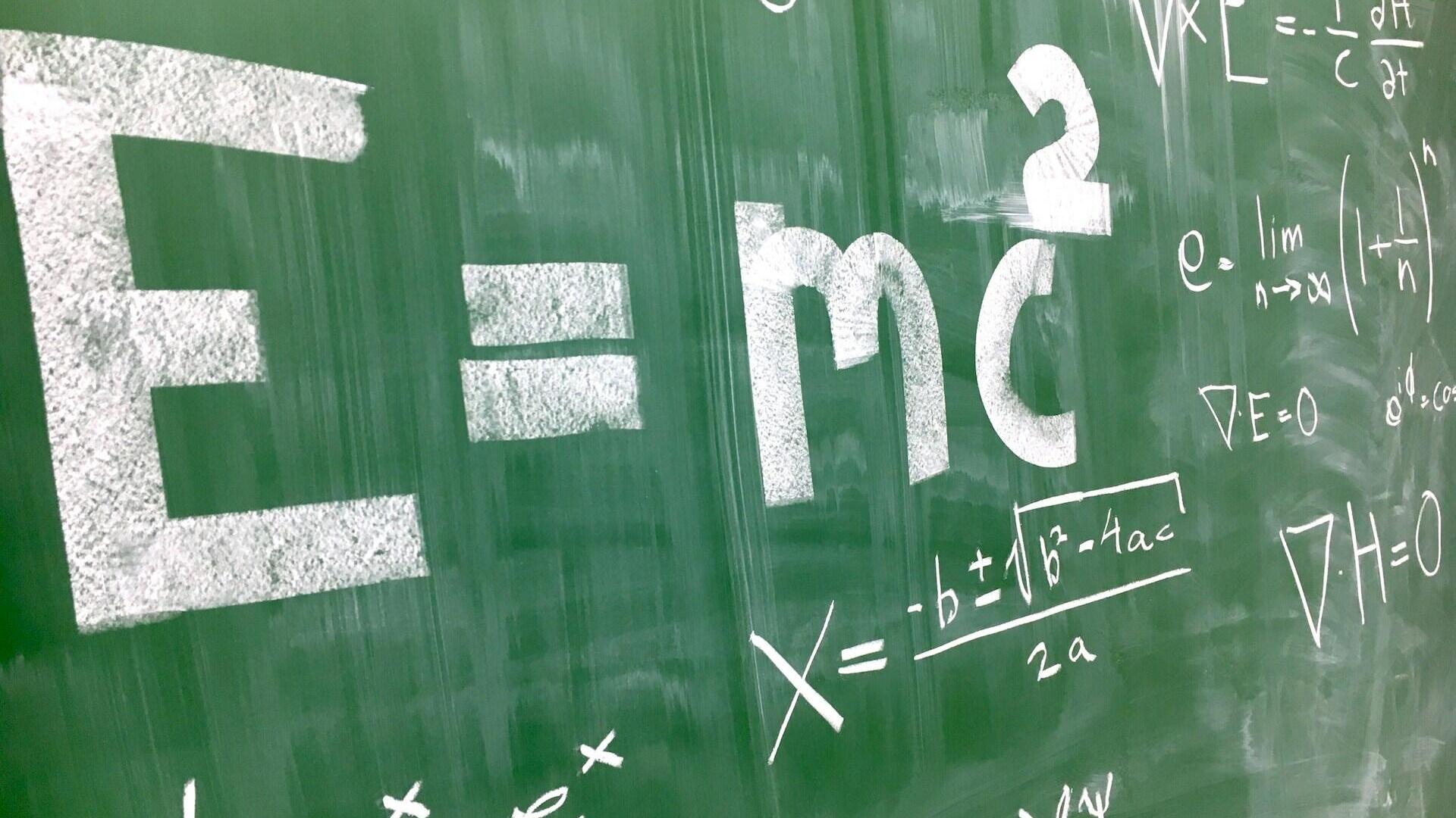 Ant žalios lentos balta kreida užrašyta matematinė formulė