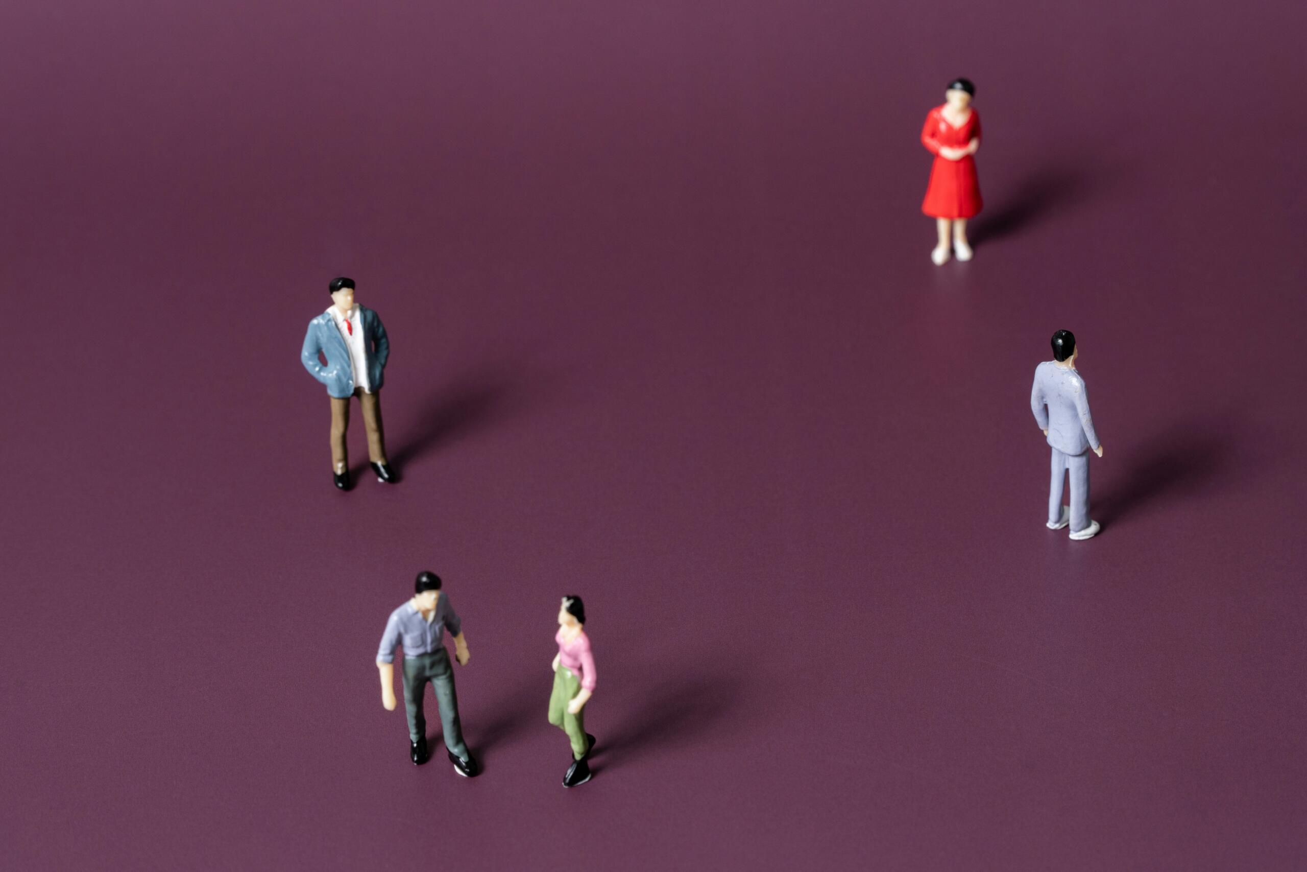 Žmonių figurėlės violetiniame fone