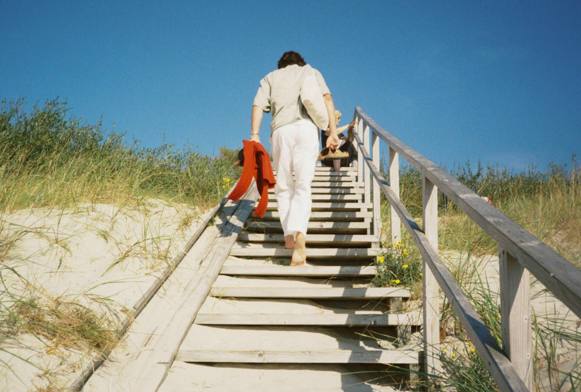 Žmogus lipa laiptais kopose.