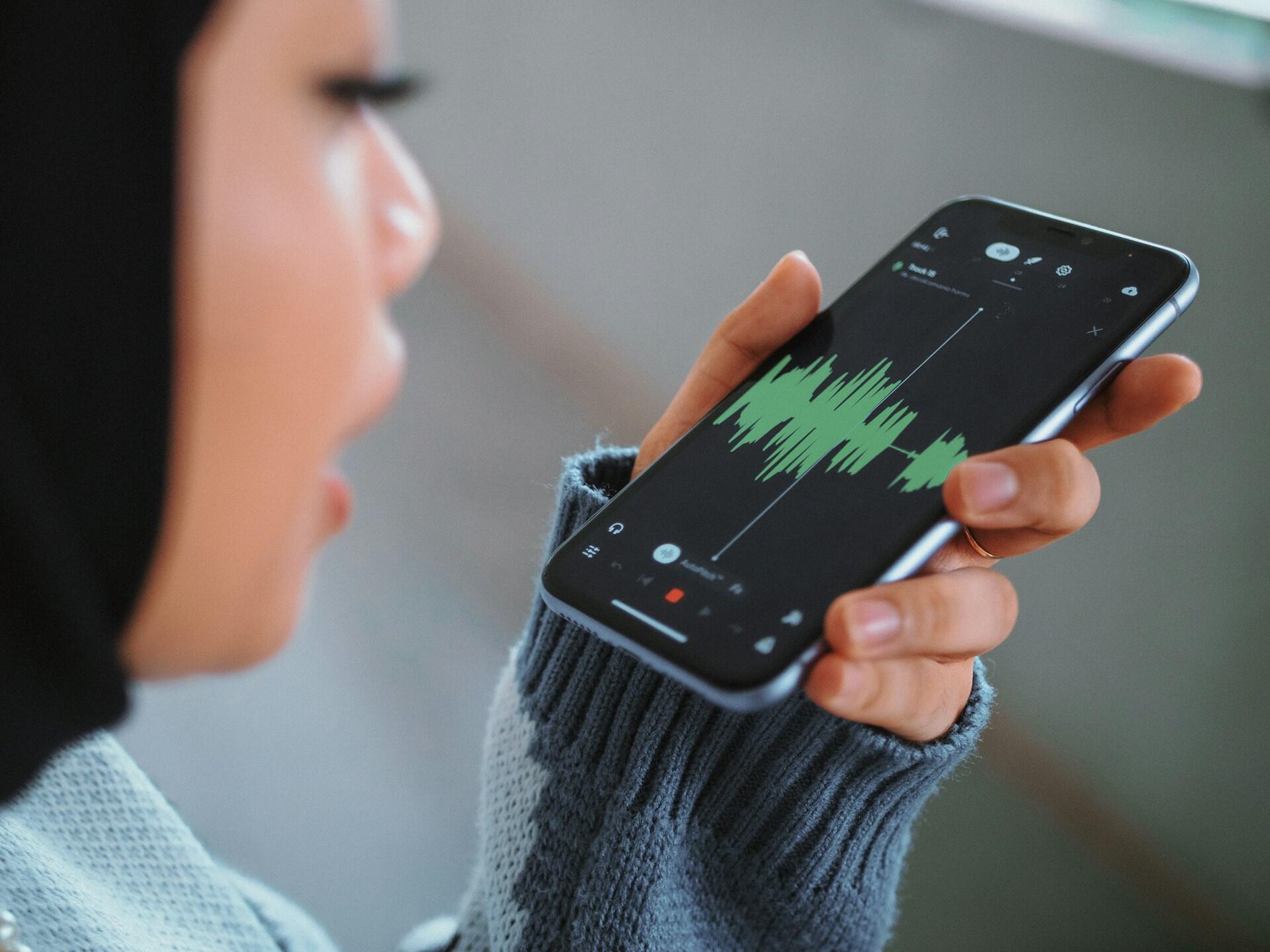 Mergina dainuoja į telefoną.