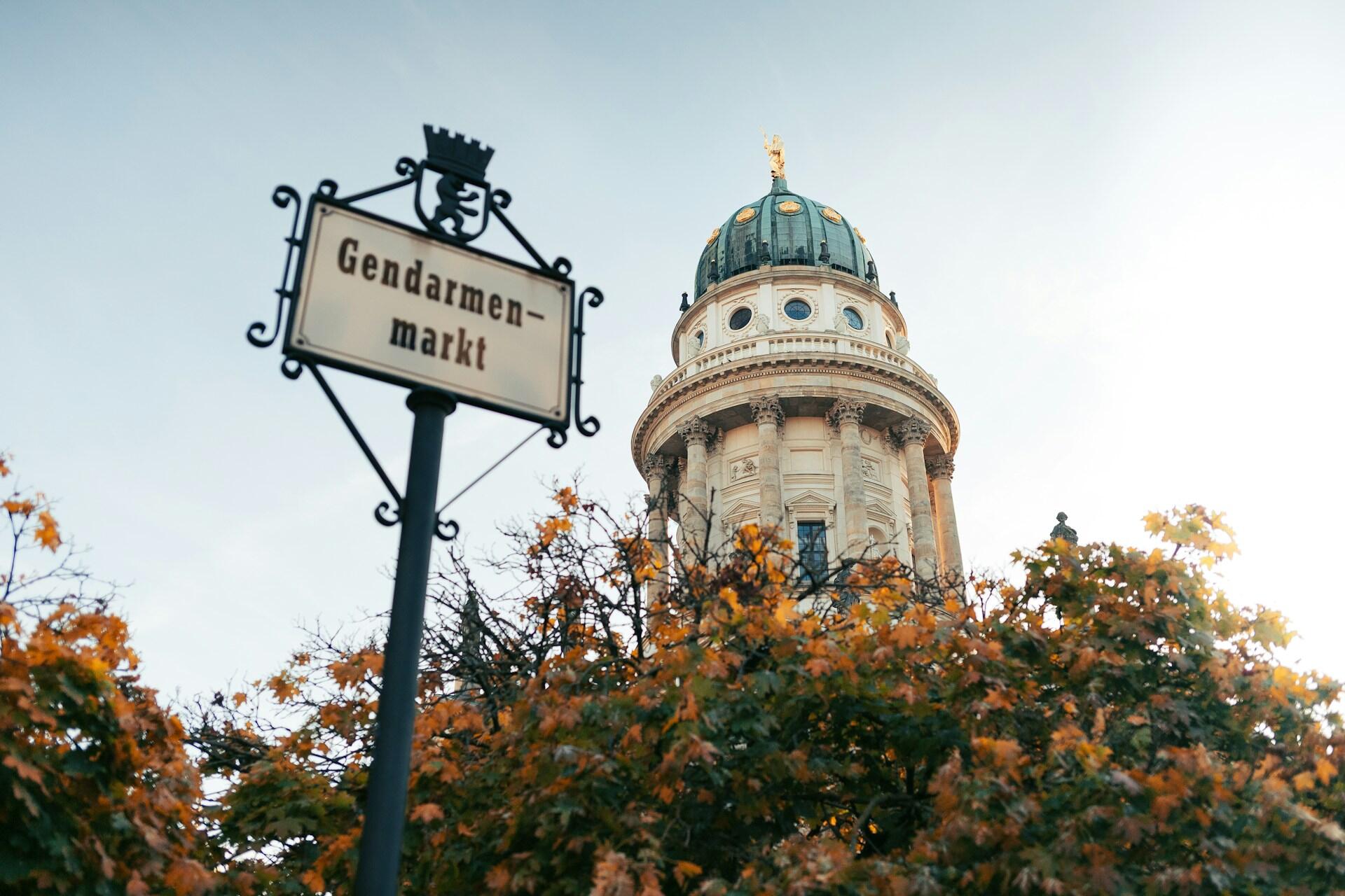Ženklas vokiečių kalba ir medis bei bokštas fone