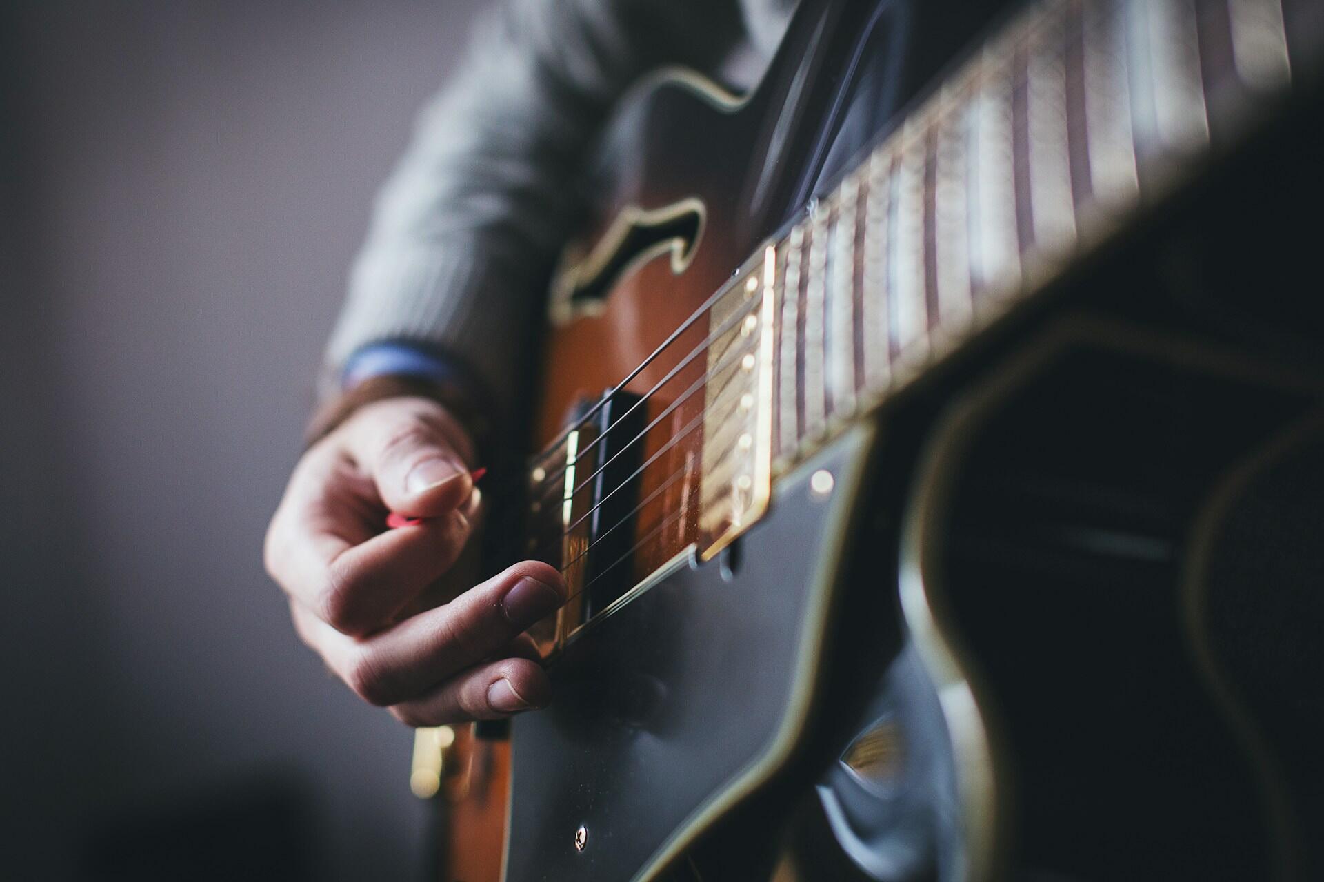 žmogus groja gitara su mediatoriumi