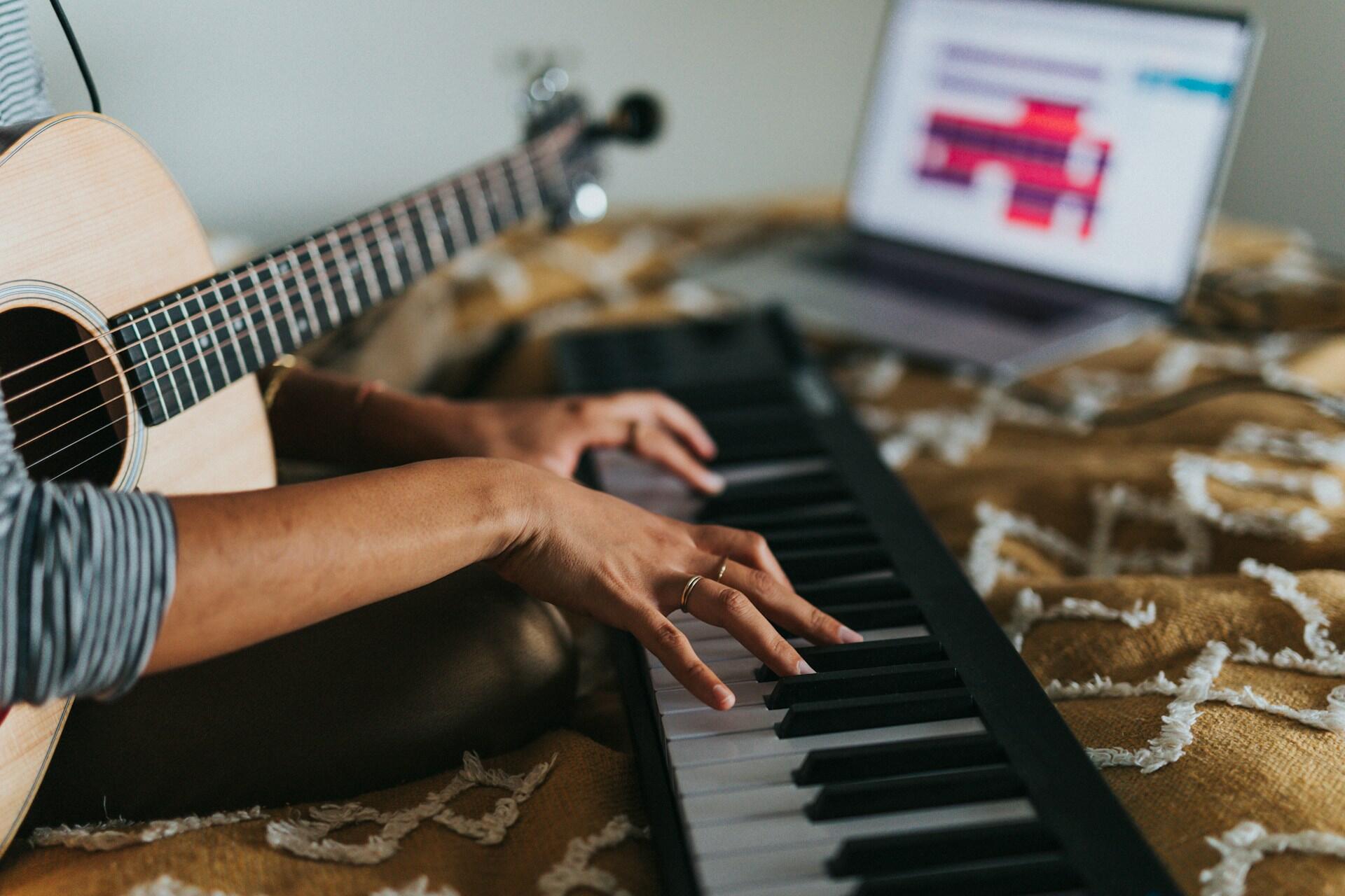 Moteris groja pianinu ir gitara.