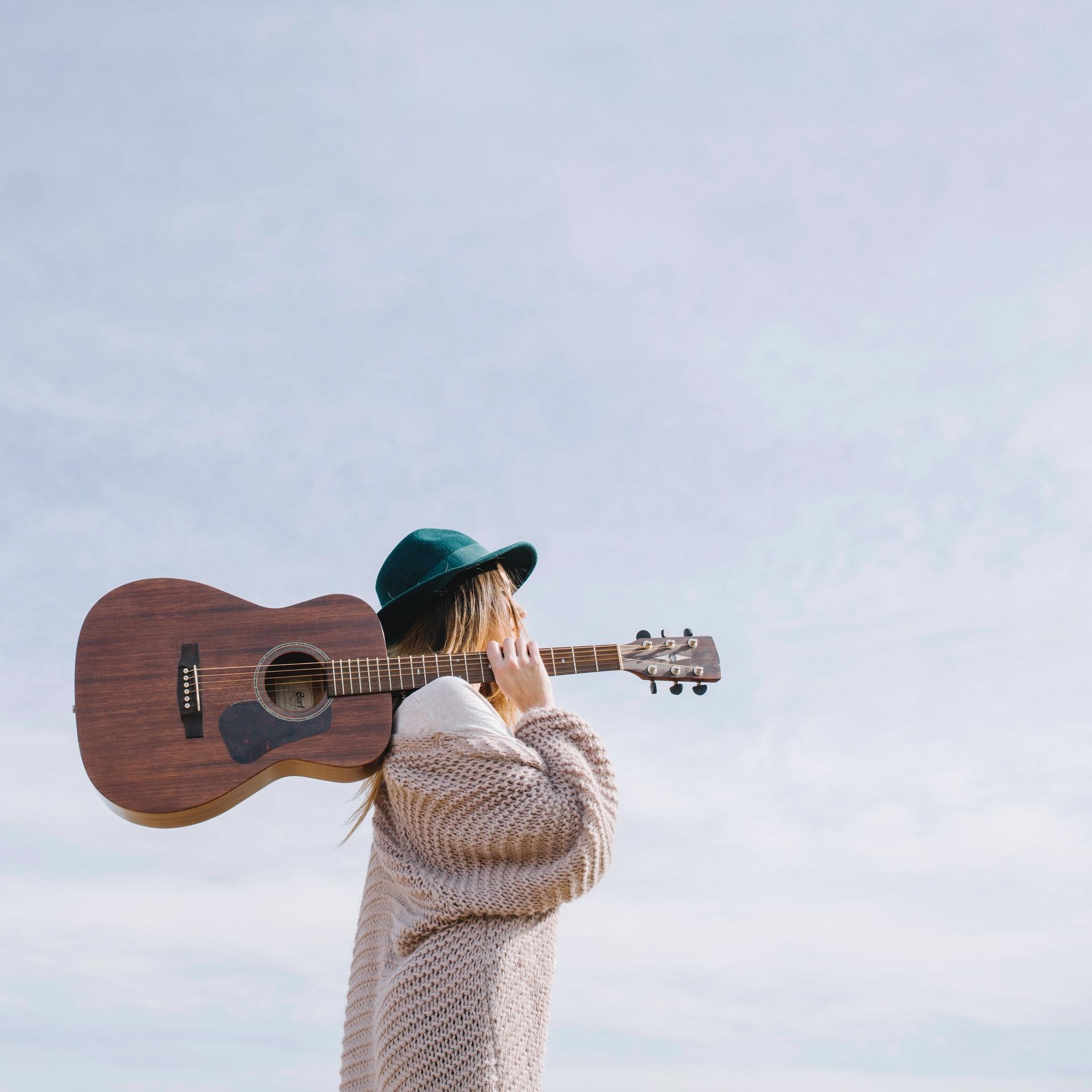 jeune femme se baladant, guitare à l'épaule