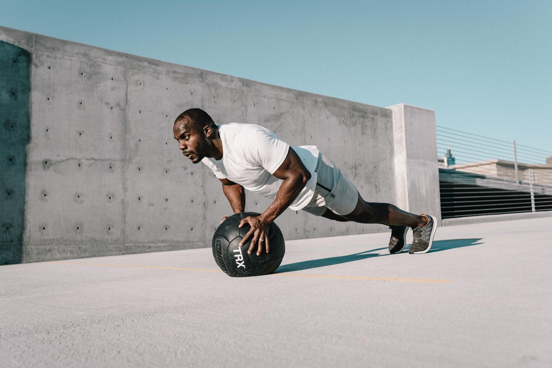 Homme qui fait la planche avec une balle d'entrainement