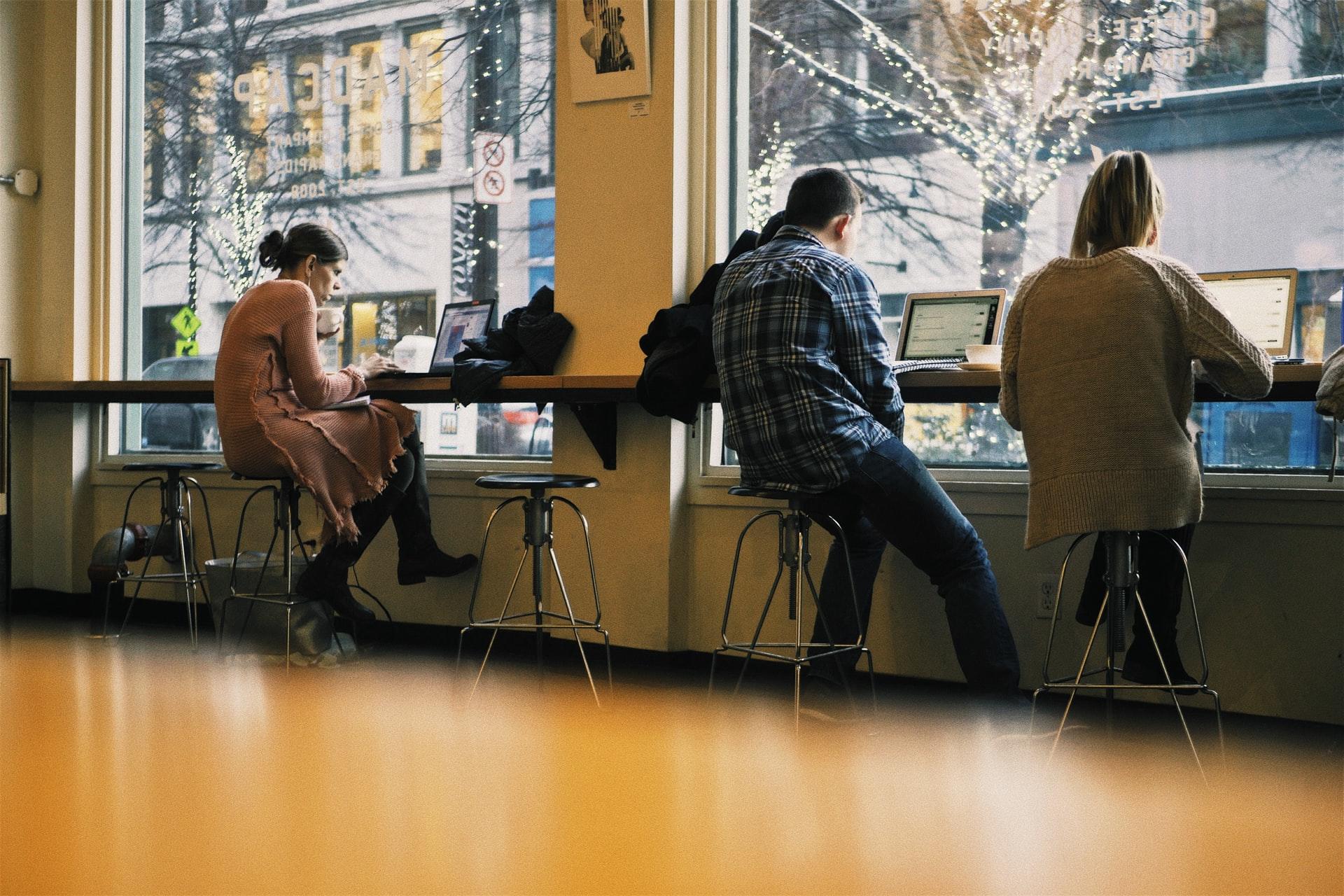 Trois personnes étudient dans un café
