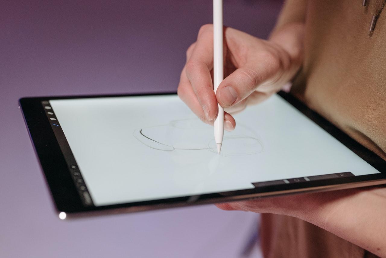 personne dessinant sur une tablette