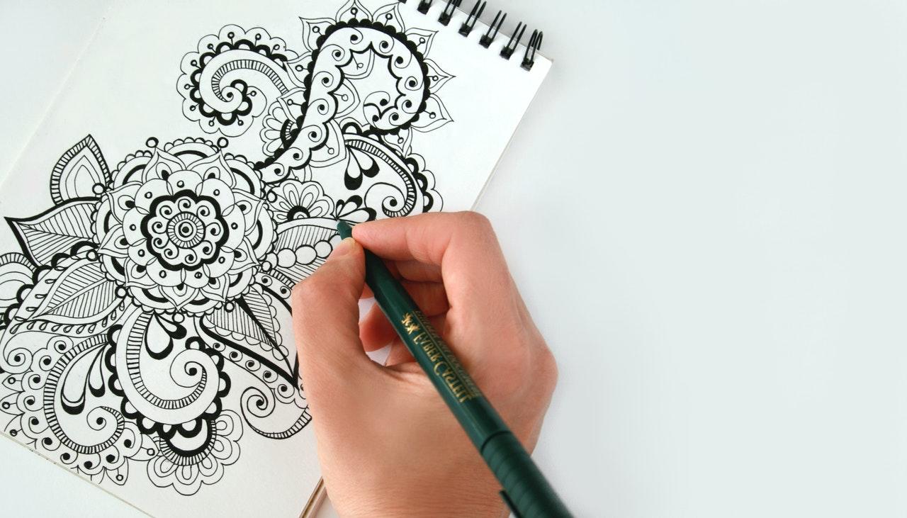 main dessinant sur un bloc-notes