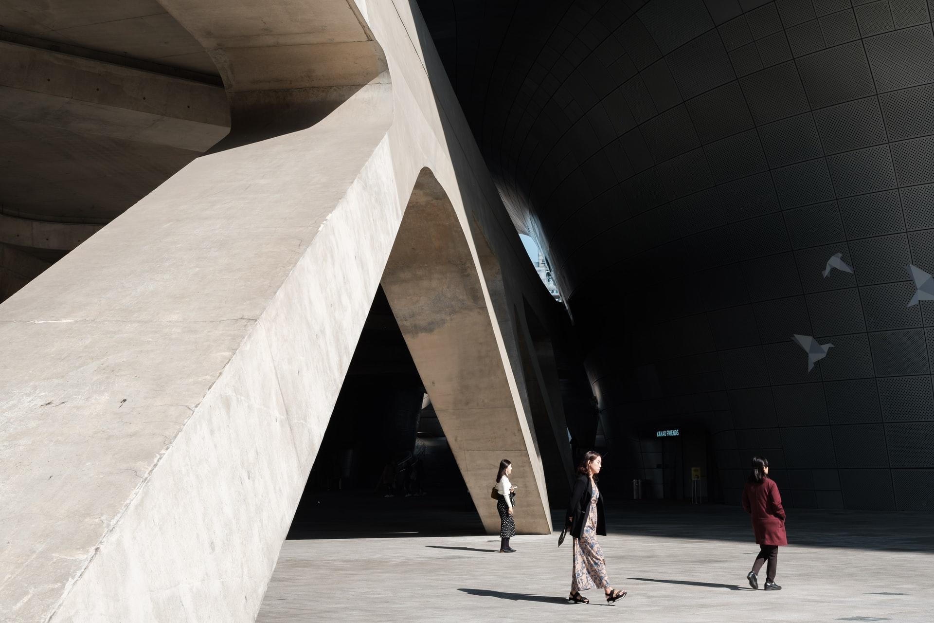 architecture et lumière entourent trois personnes qui se baladent à Seoul