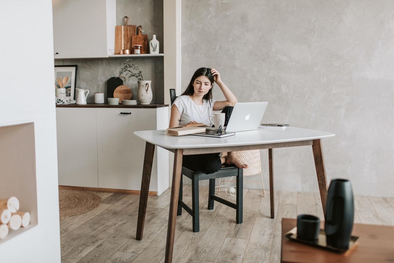 jeune femme etudiant de chez elle avec son laptop apple