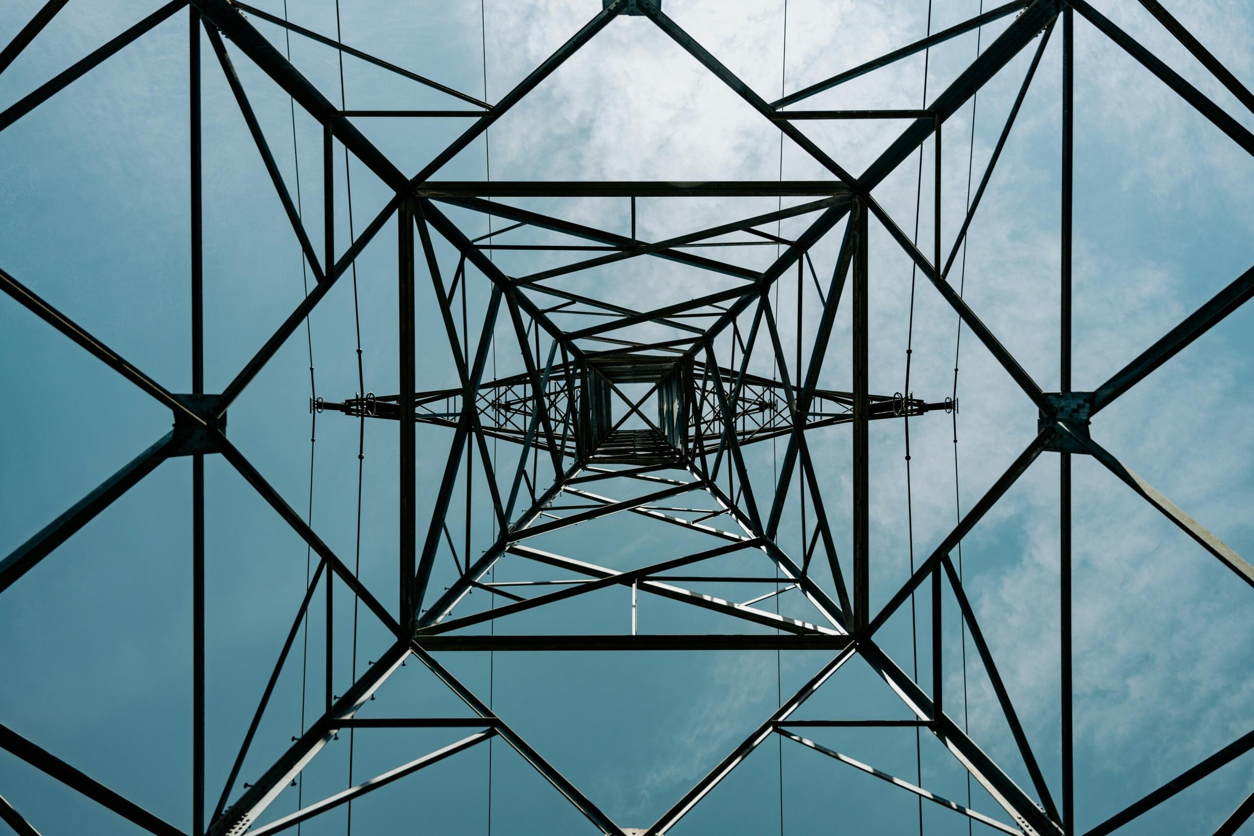 elektrības tornis no apakšas uz debesu fona