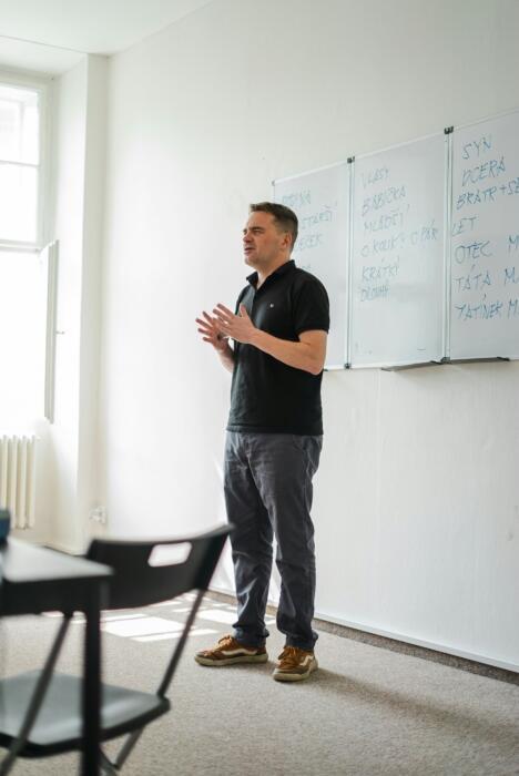 skolotājs klases priekšā skaidro