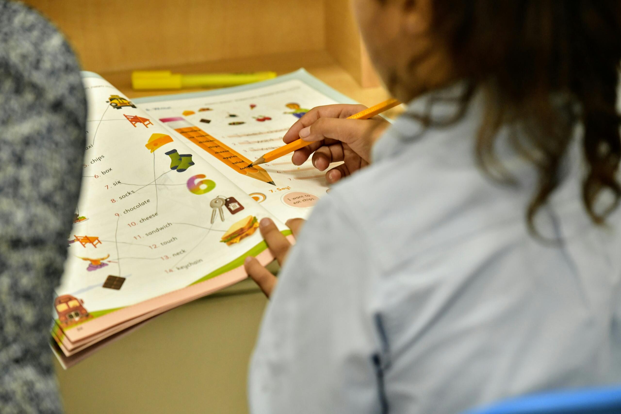 sieviete tur zīmuli pie angļu valodas darba grāmatas
