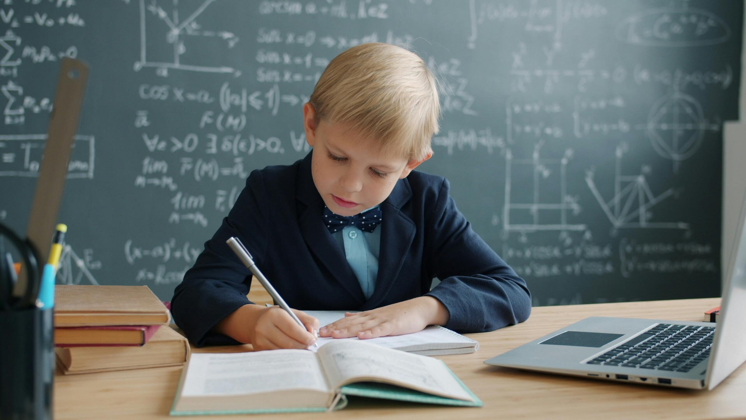 bērns matemātikas klasē pie skolotāja galda