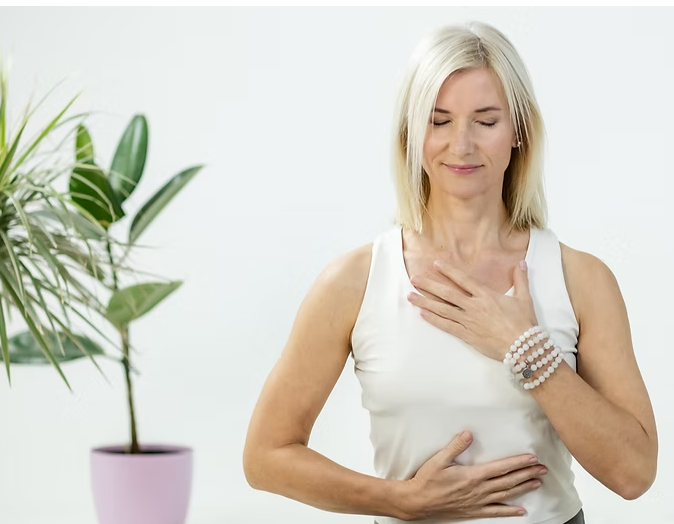 Sieviete veic apzinātas elpošanas un meditācijas vingrinājumu.