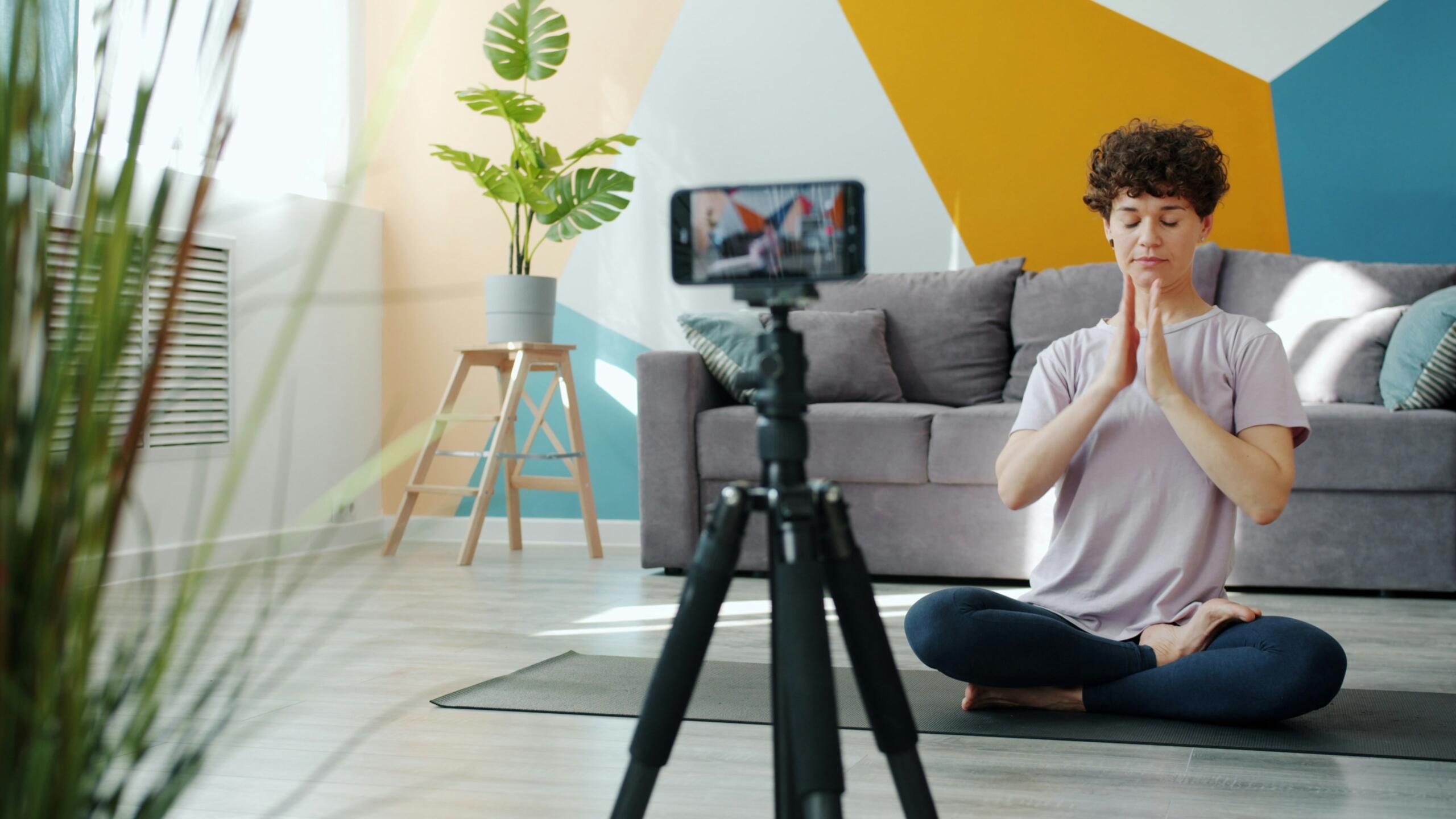 Persona, kas mājas vidē veic meditāciju.