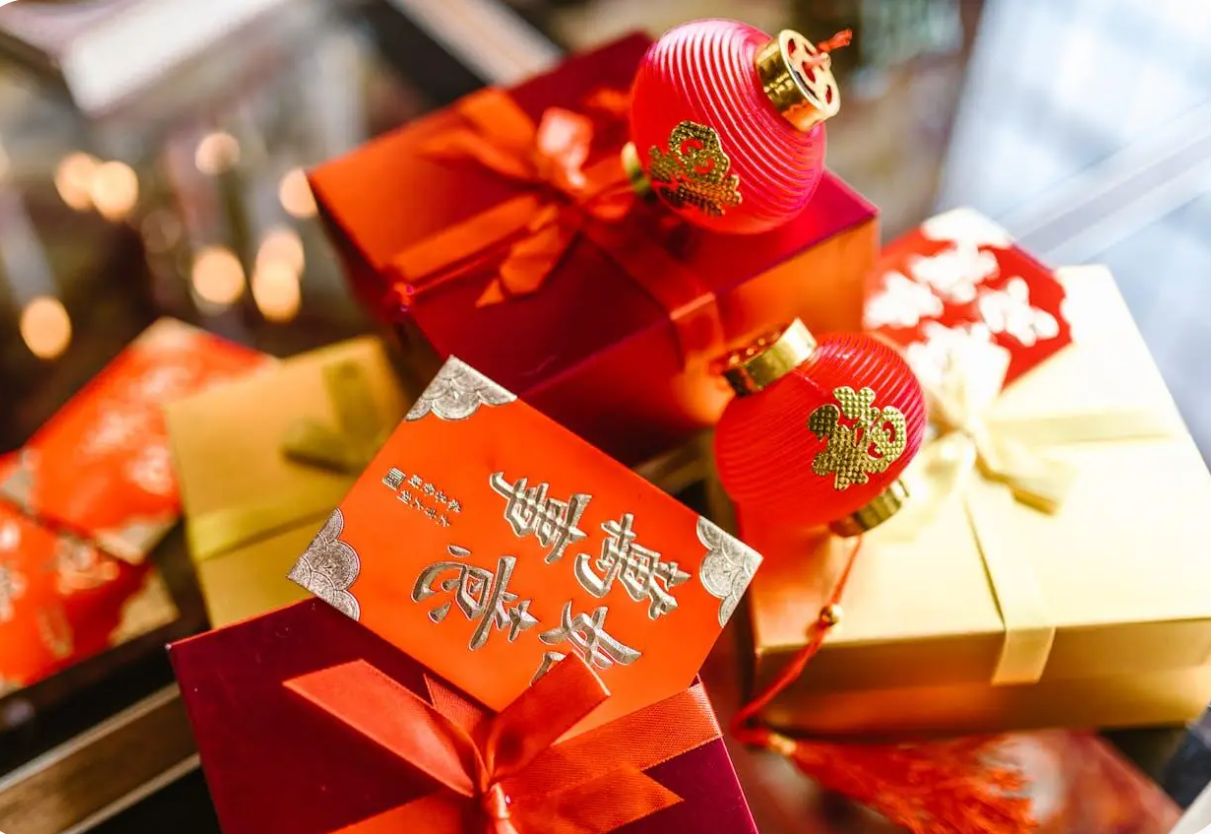 Ķīniešu Jaunā gada dāvanas ar sarkanām laternām un veiksmes simboliem.