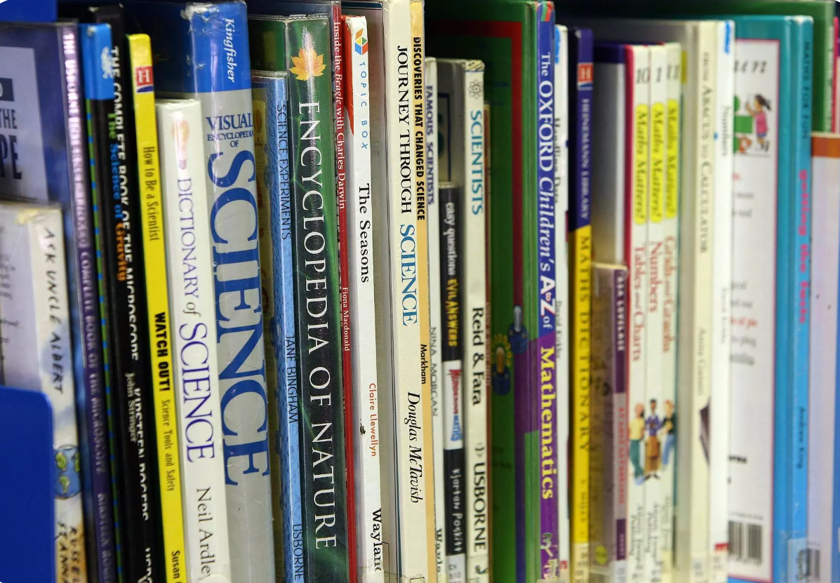 Grāmatu plaukts ar dažādām zinātnes un izglītības grāmatām.