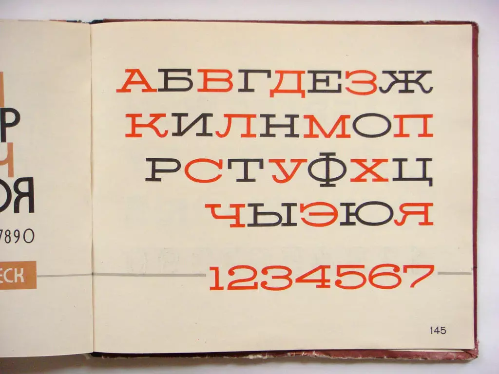 Atvērta grāmata ar krievu alfabētu kirilicā un cipariem.