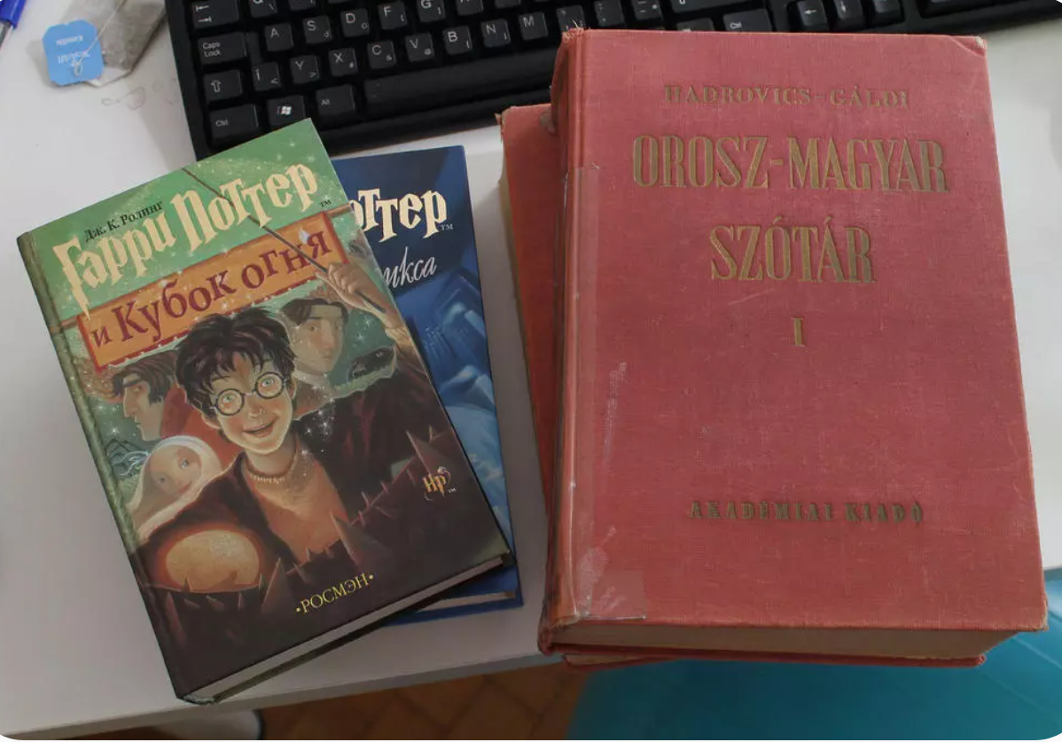 Uz galda redzamas grāmatas krievu valodā un vārdnīca.