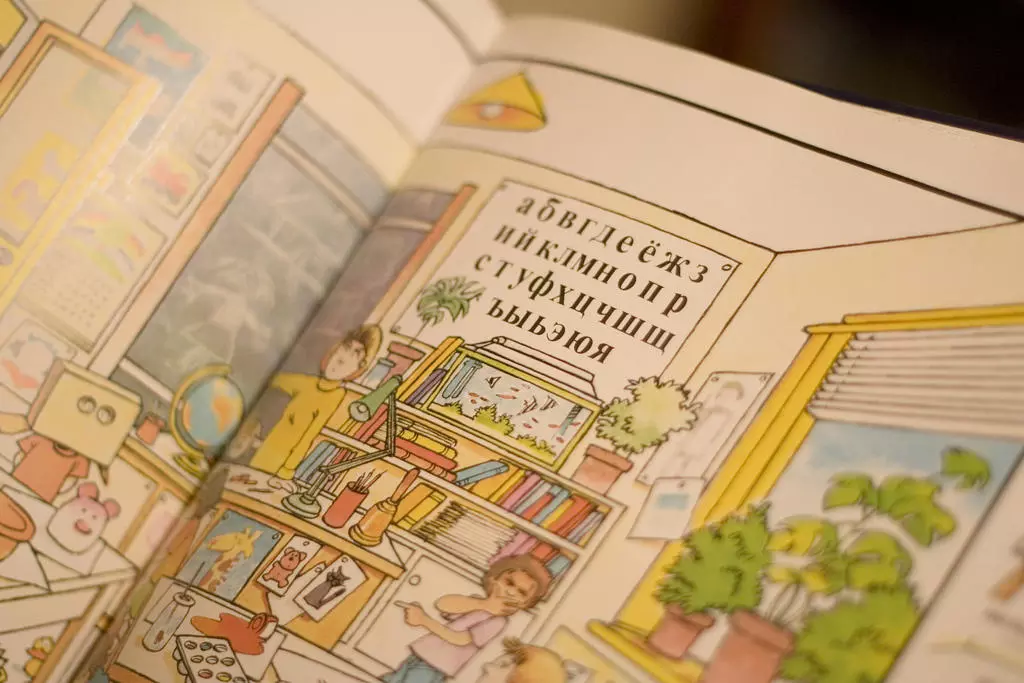 Ilustrēta grāmata ar krievu alfabētu un klases ainu.