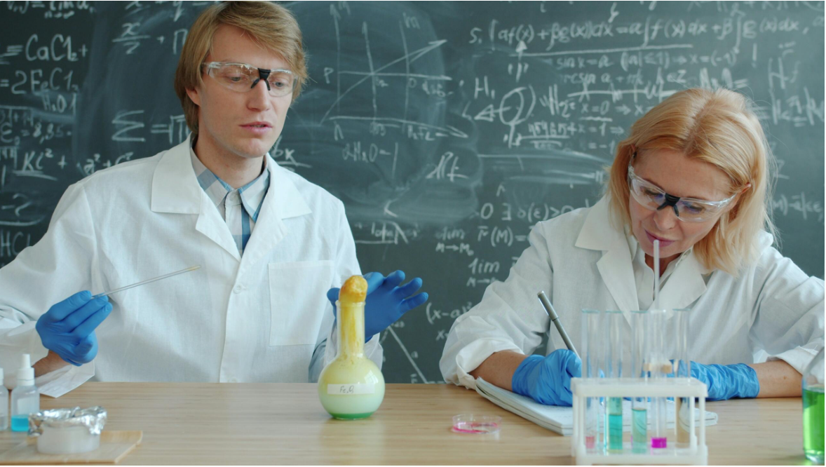 Divi cilvēki laboratorijā veic ķīmijas eksperimentu