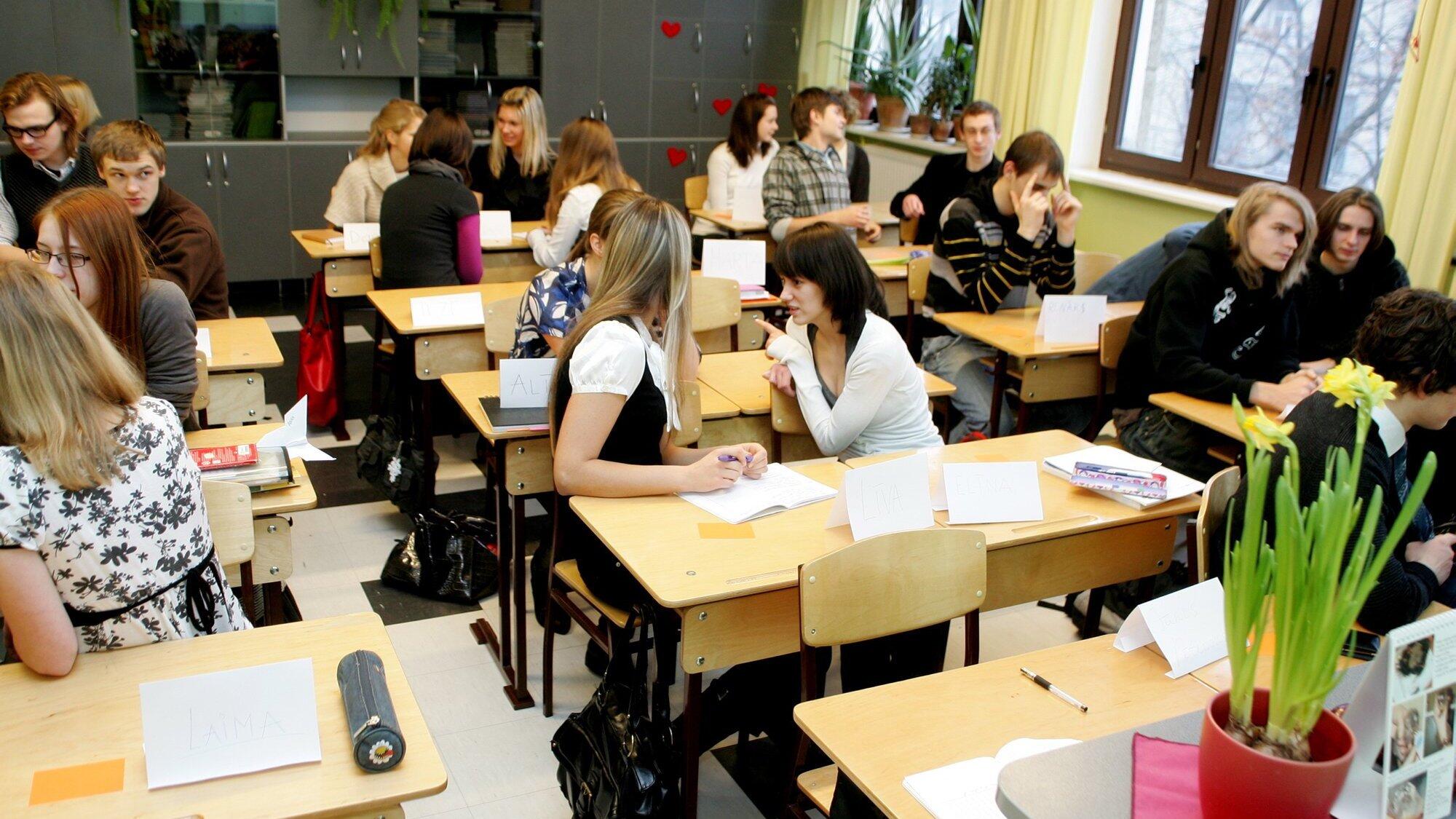 skolēni klasē sarunājas