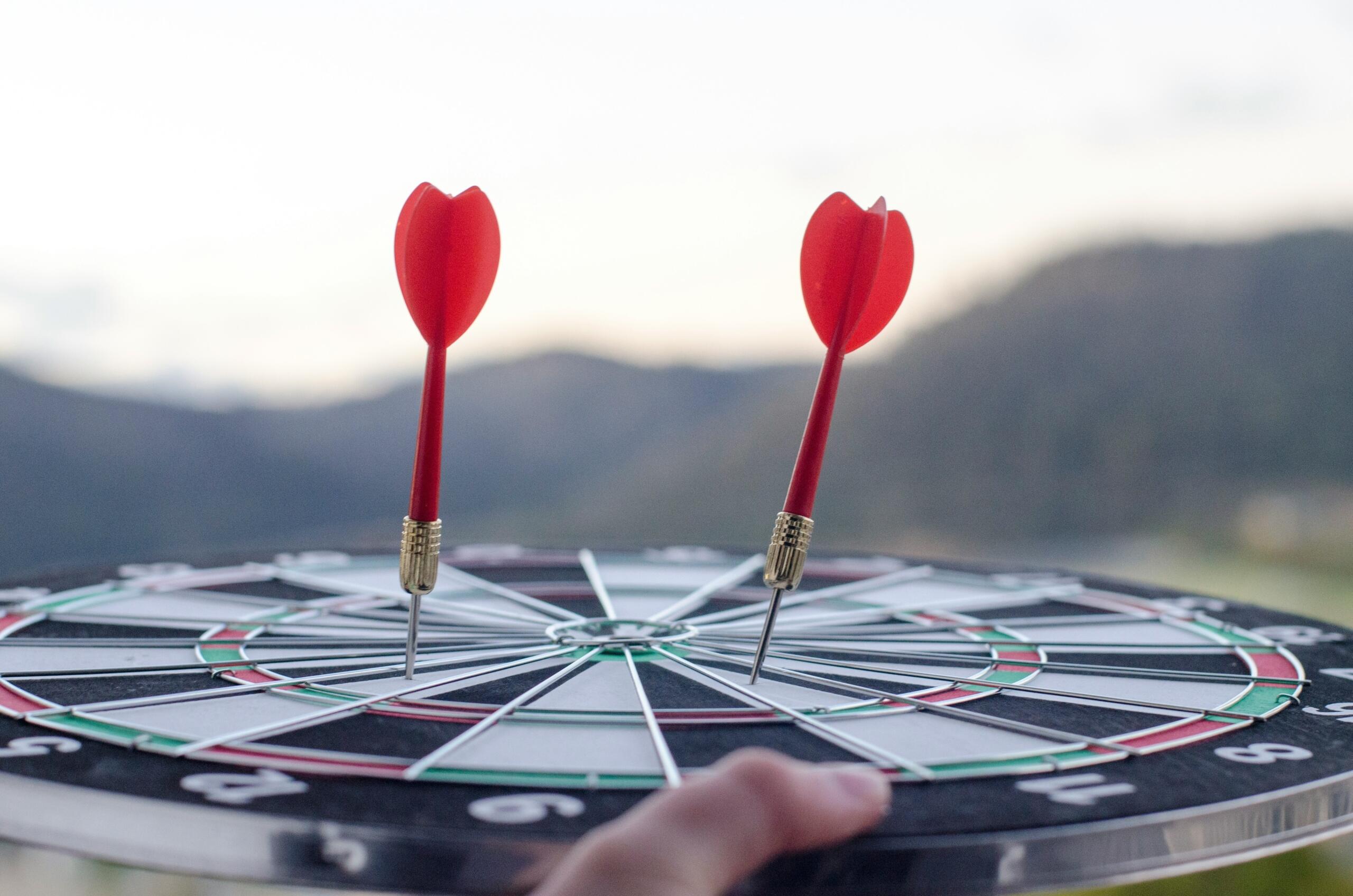 šautriņu dēlis ar divām sarkanām šautriņām