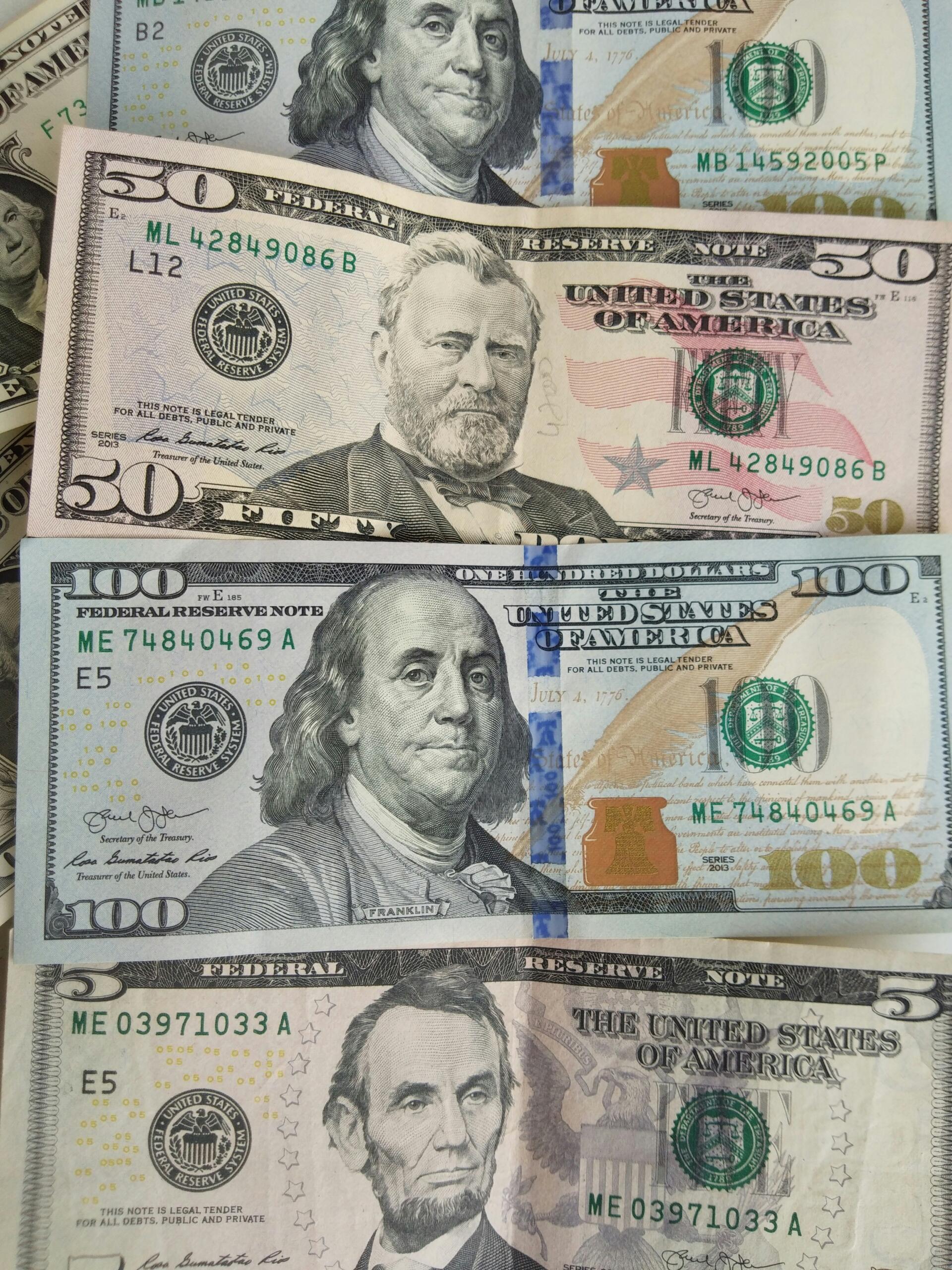 Dažādu nominālu ASV dolāru banknotes.