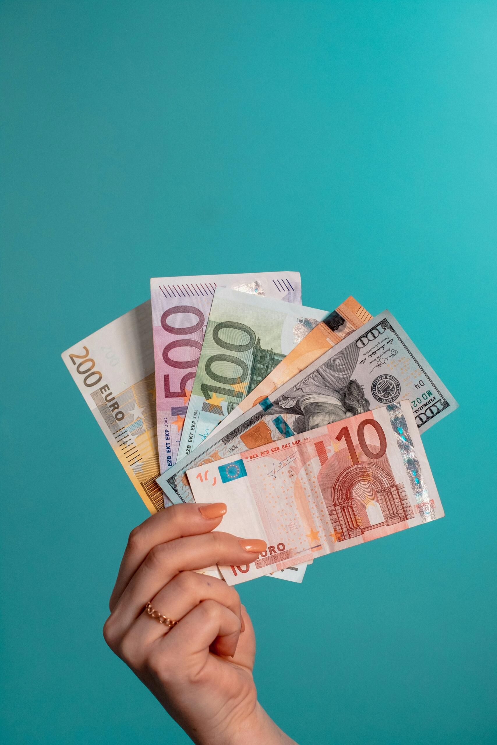 Sieviete tur vairākas naudas banknotes.