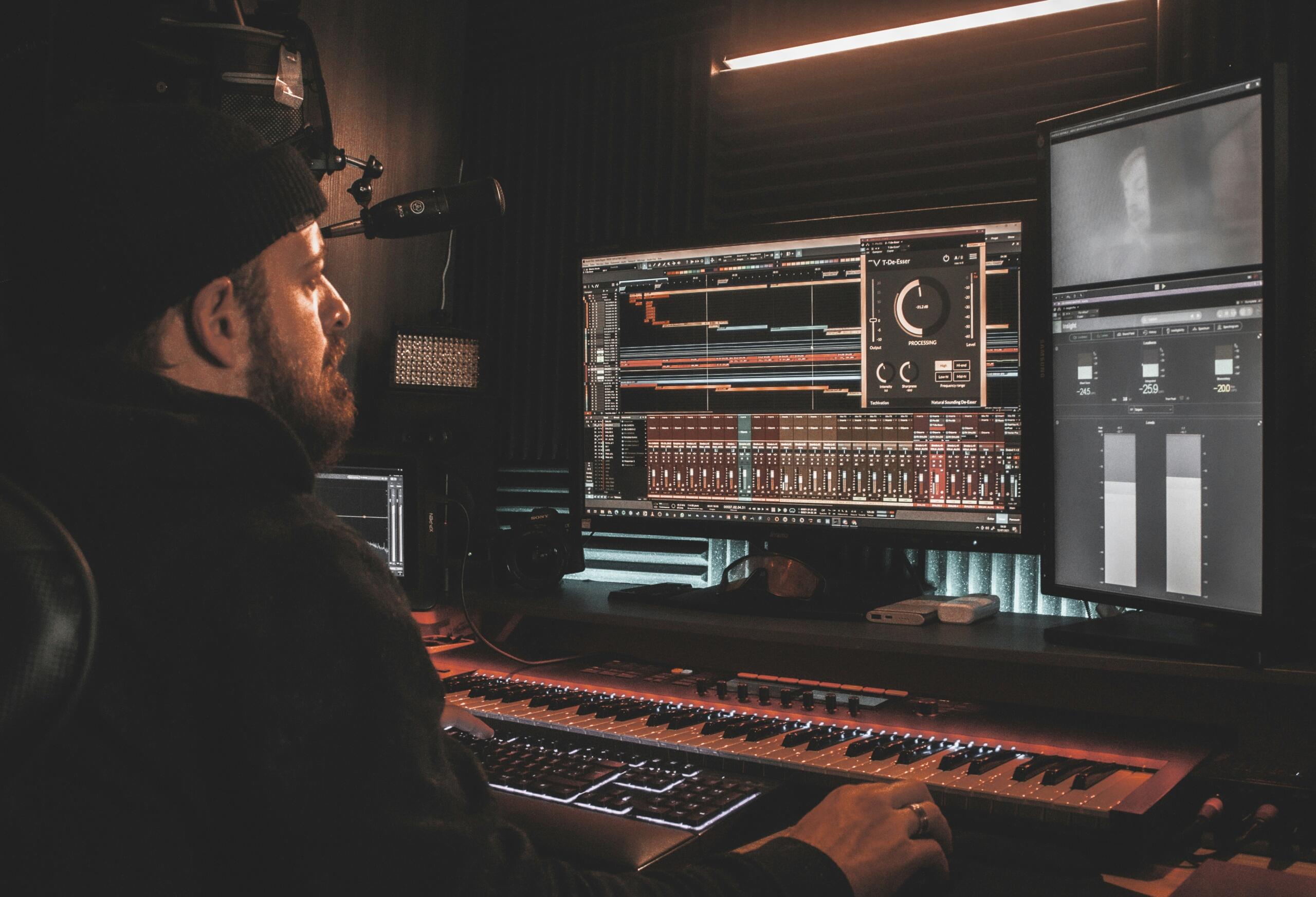 Vīrietis strādā pie profesionālas audio montāžas pults.
