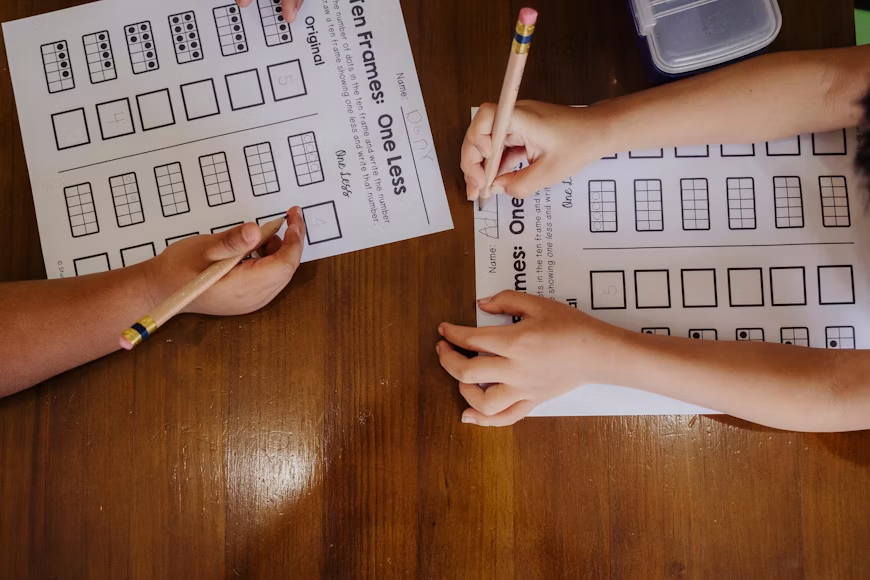 Dvoje djece zajedno rješava matematičke zadatke, razvijajući logičko razmišljanje, koncentraciju i vještine rješavanja problema.