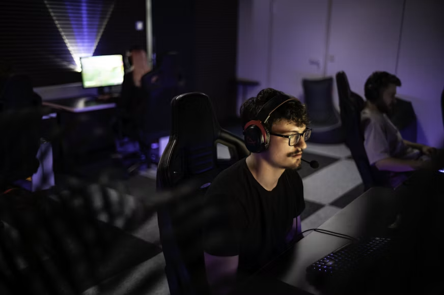Na slici je prikazan moderan prostor 1337Camp-a koji uspešno spaja tehnologiju, dizajn i inspirativnu atmosferu. Ambijent odlikuje jedinstven dizajn inspirisan dozoom, upotpunjen prilagodljivim LED osvetljenjem i podnim svetlima u boji koja stvaraju savršen balans između opuštanja i fokusa. Prostor je osmišljen tako da pruži idealno okruženje za gejmere, kreativce i tehnološke entuzijaste da razvijaju svoje potencijale i ostvaruju ciljeve.