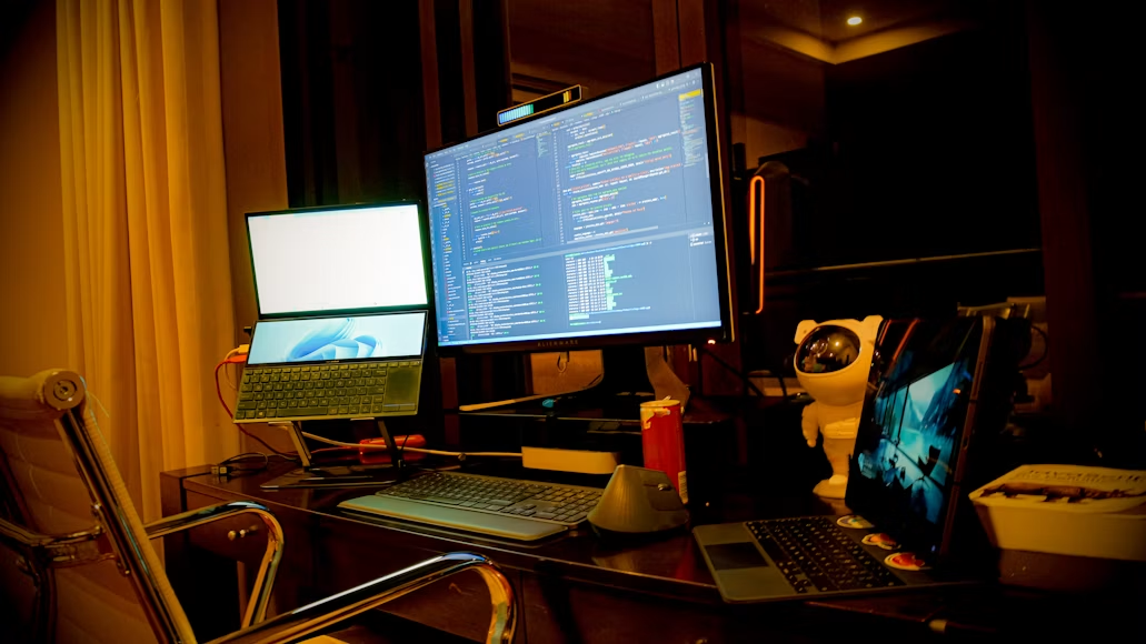 Radni sto sa dva monitora i laptopom, opremljen kao moderno i produktivno radno okruženje za programera.