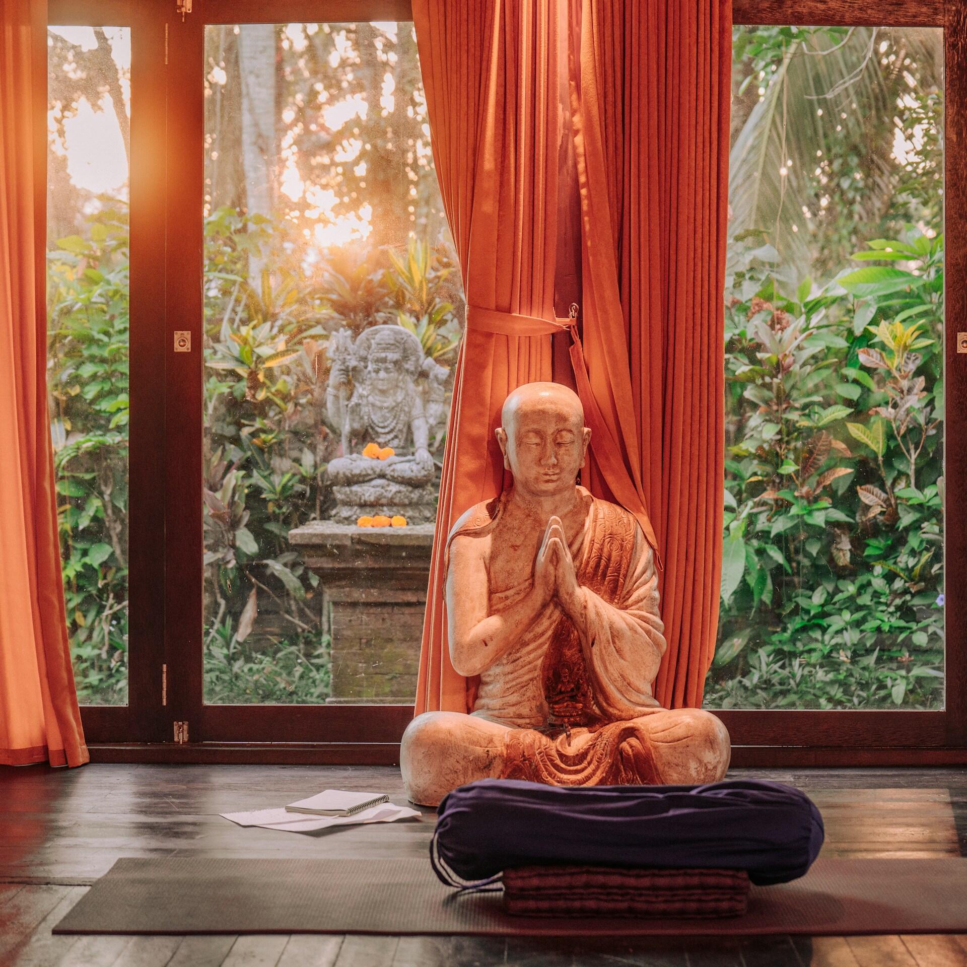 Buddha statue in meditation pose inside a peaceful yoga and meditation space
