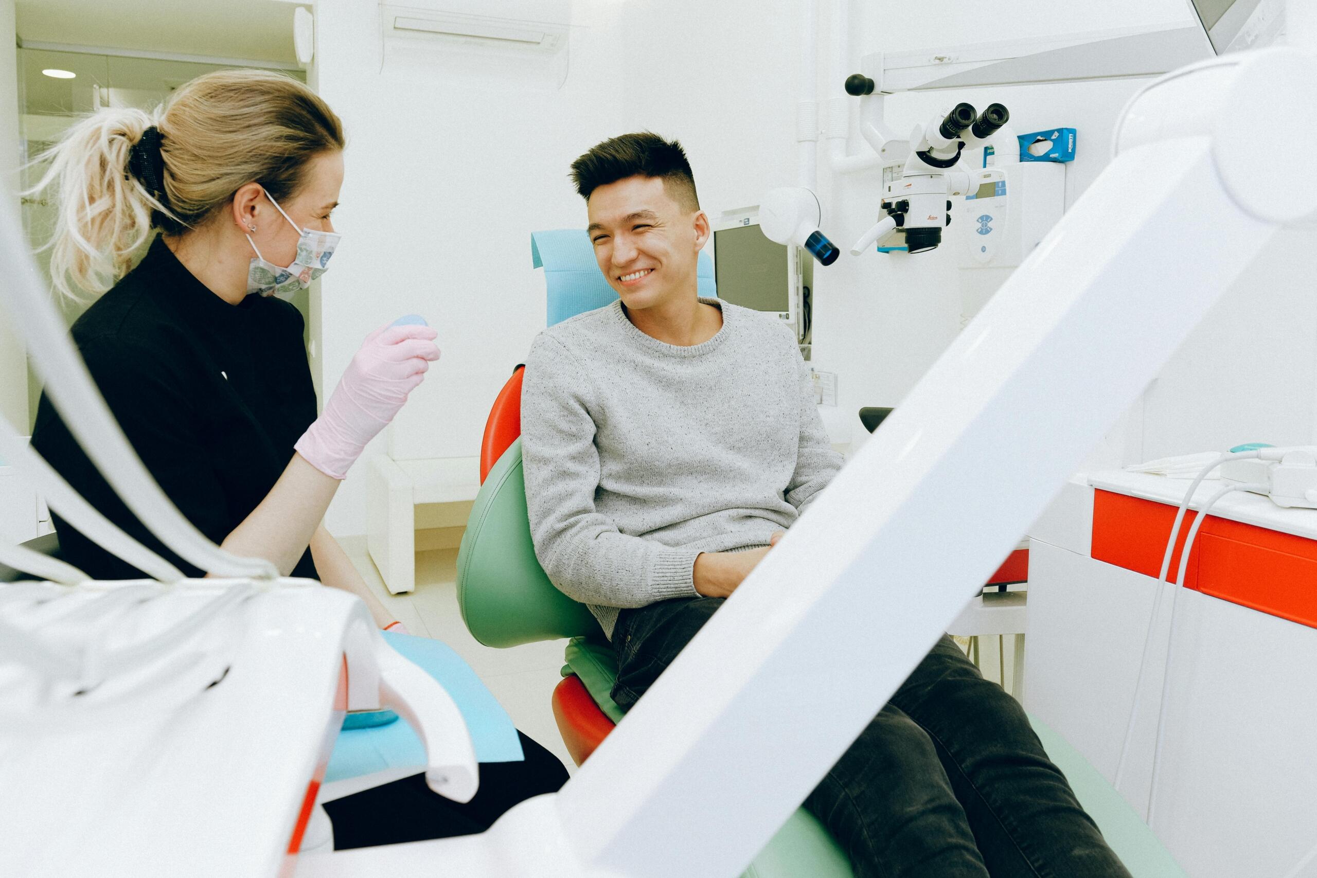 Nurse in uniform assisting a patient in a bright hospital room.