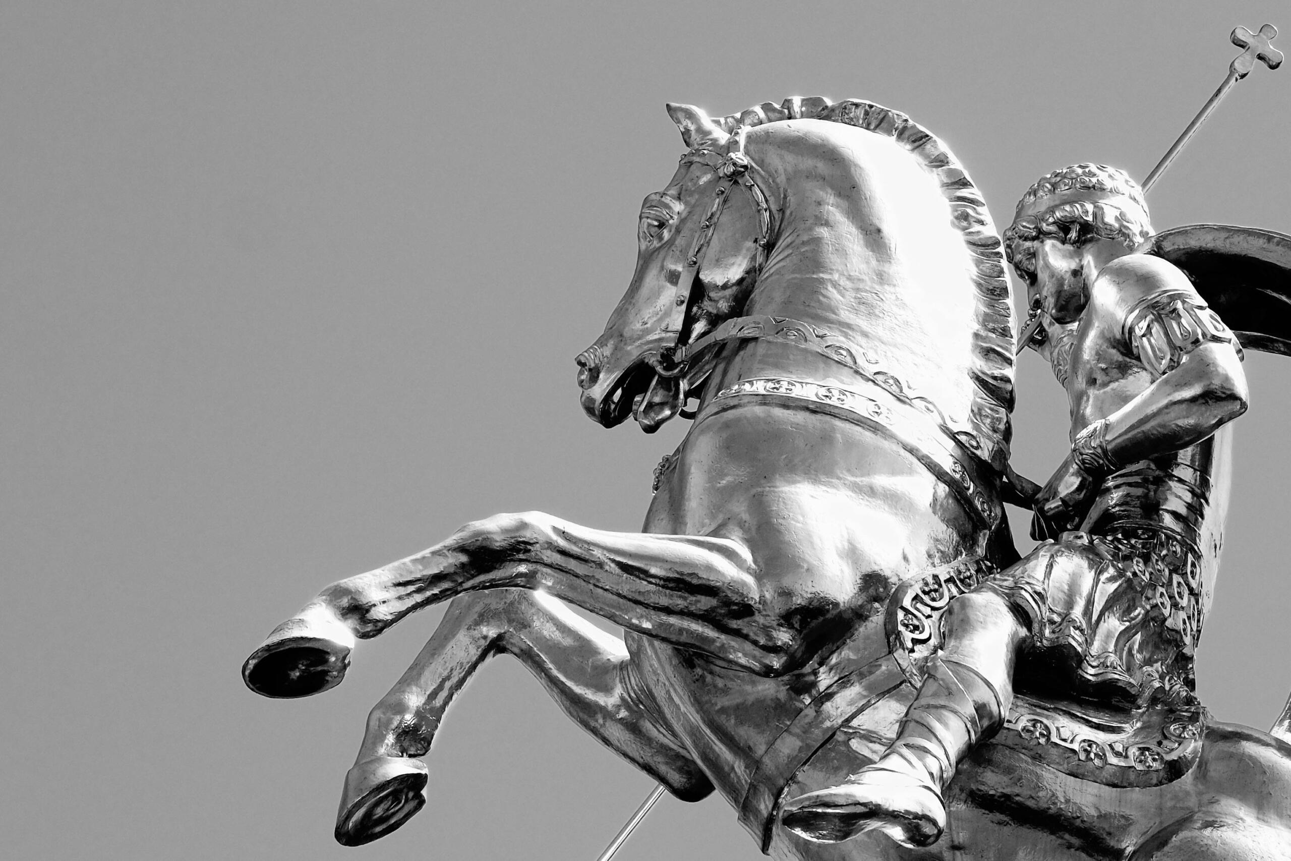 Silver statue of a knight on horseback raising his sword.
