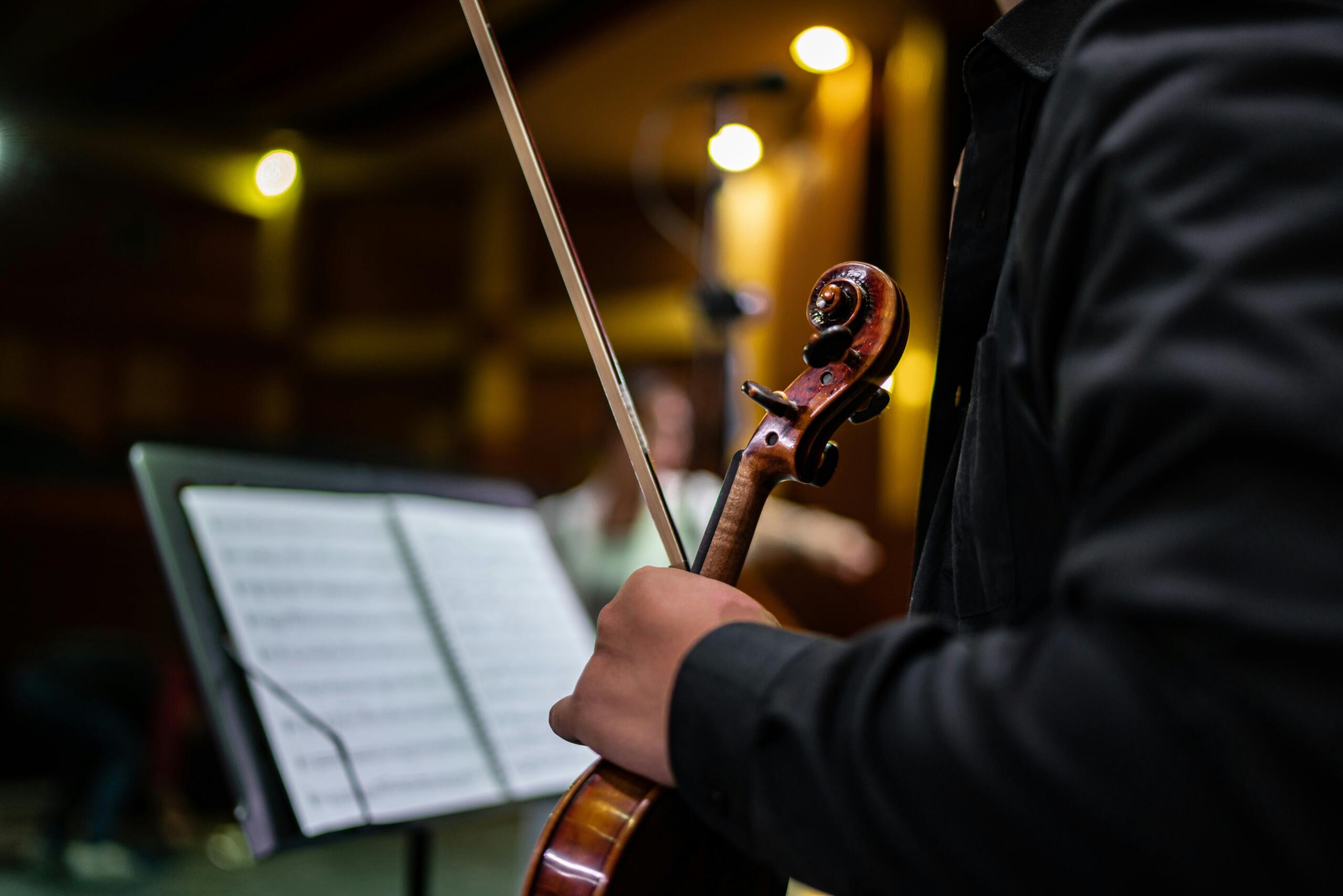 A violinist preparing to play according to the notes in front of him