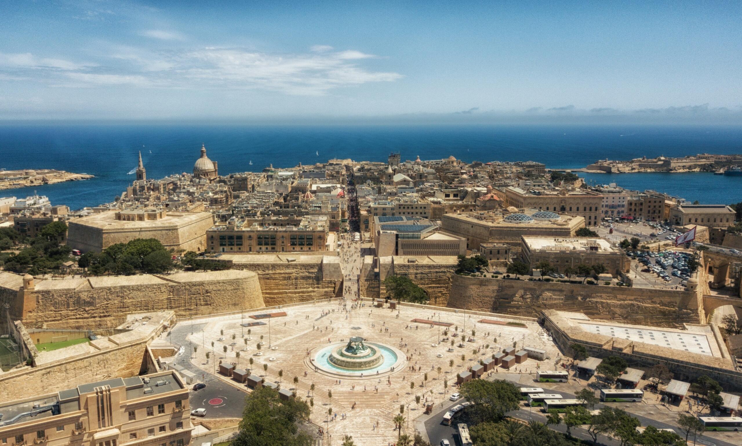 fountain and yellow limestone buildings on a peninsula