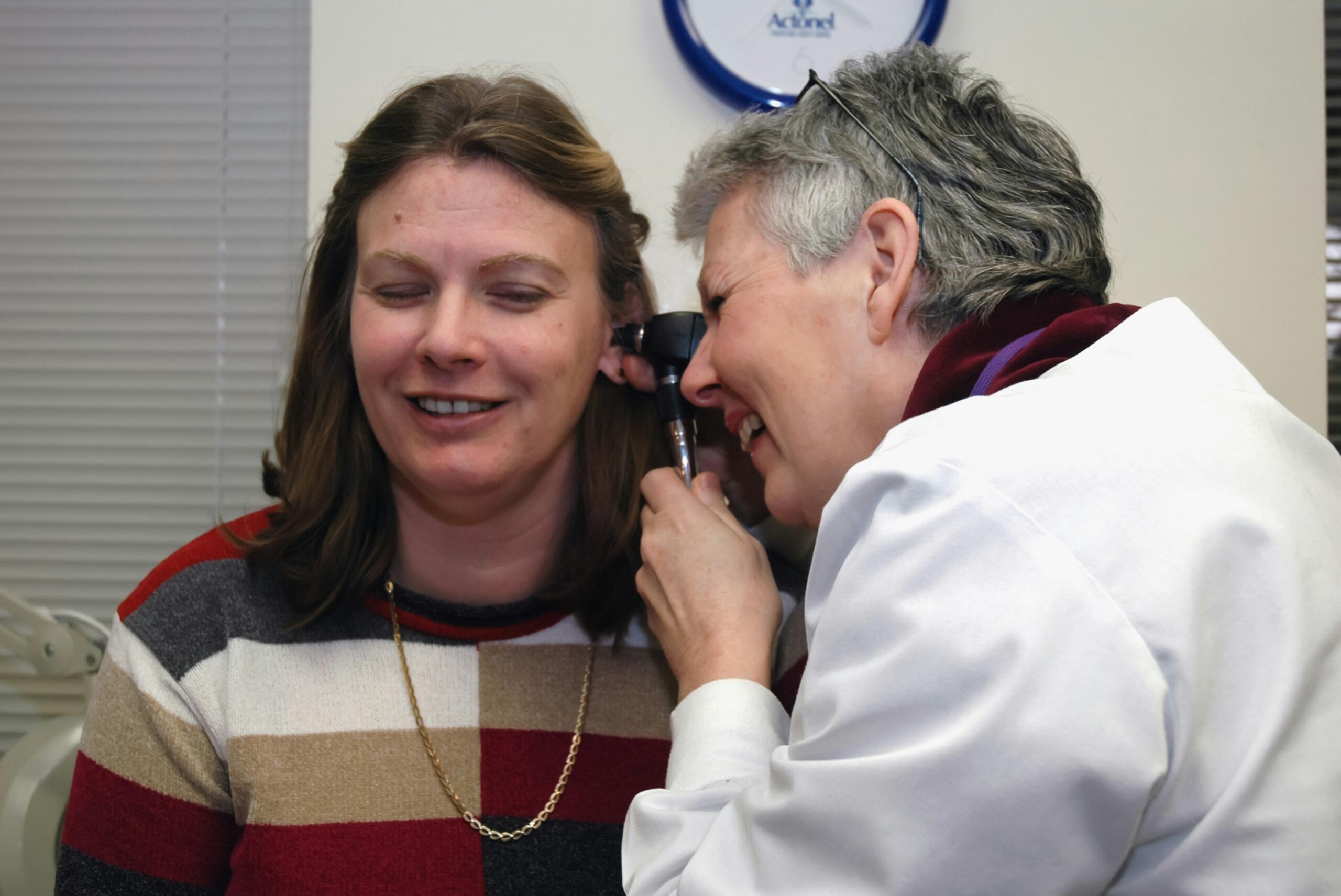 ENT doctor examining a patient’s ear with an otoscope