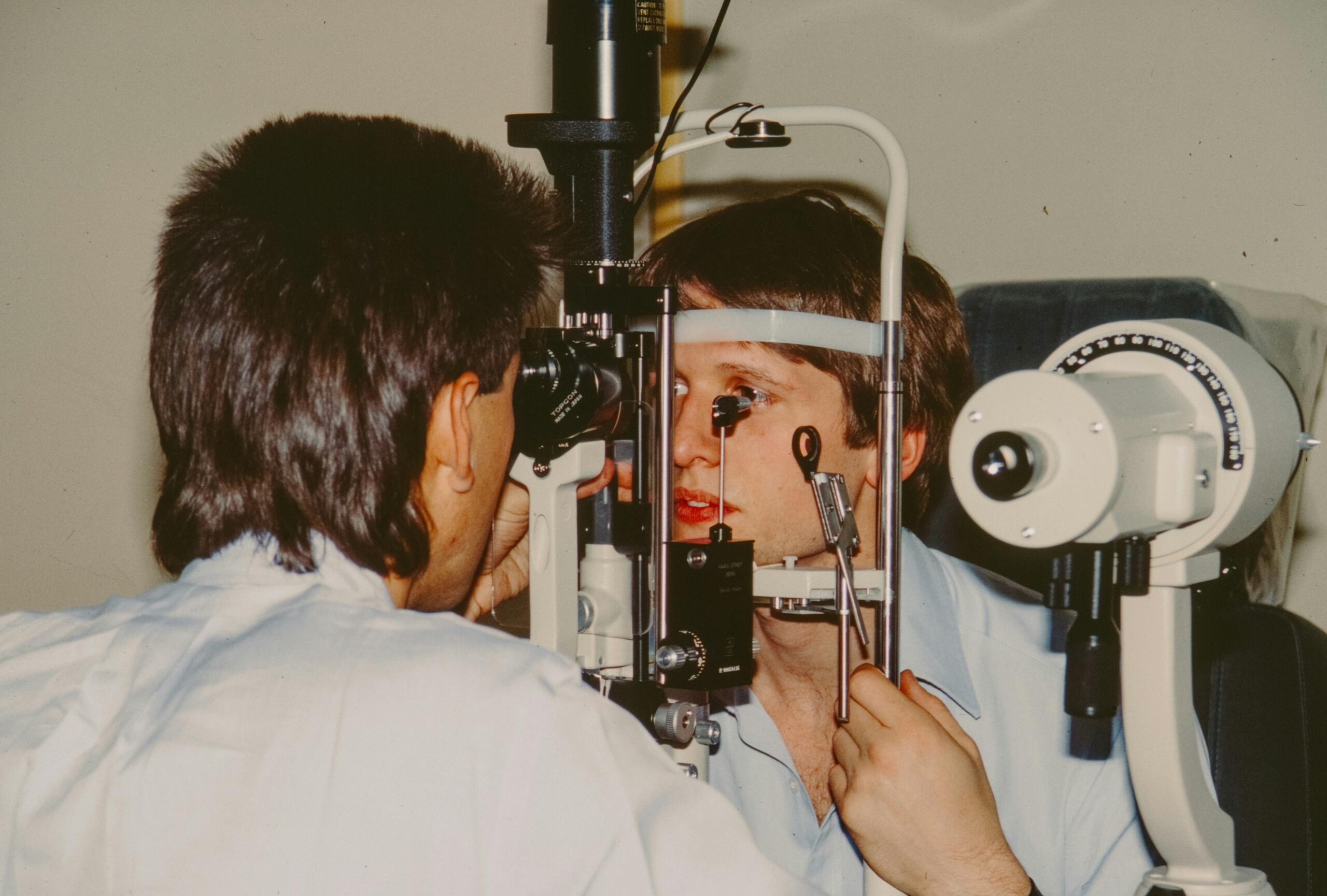 Optometrist examining a patient’s eye using diagnostic equipment