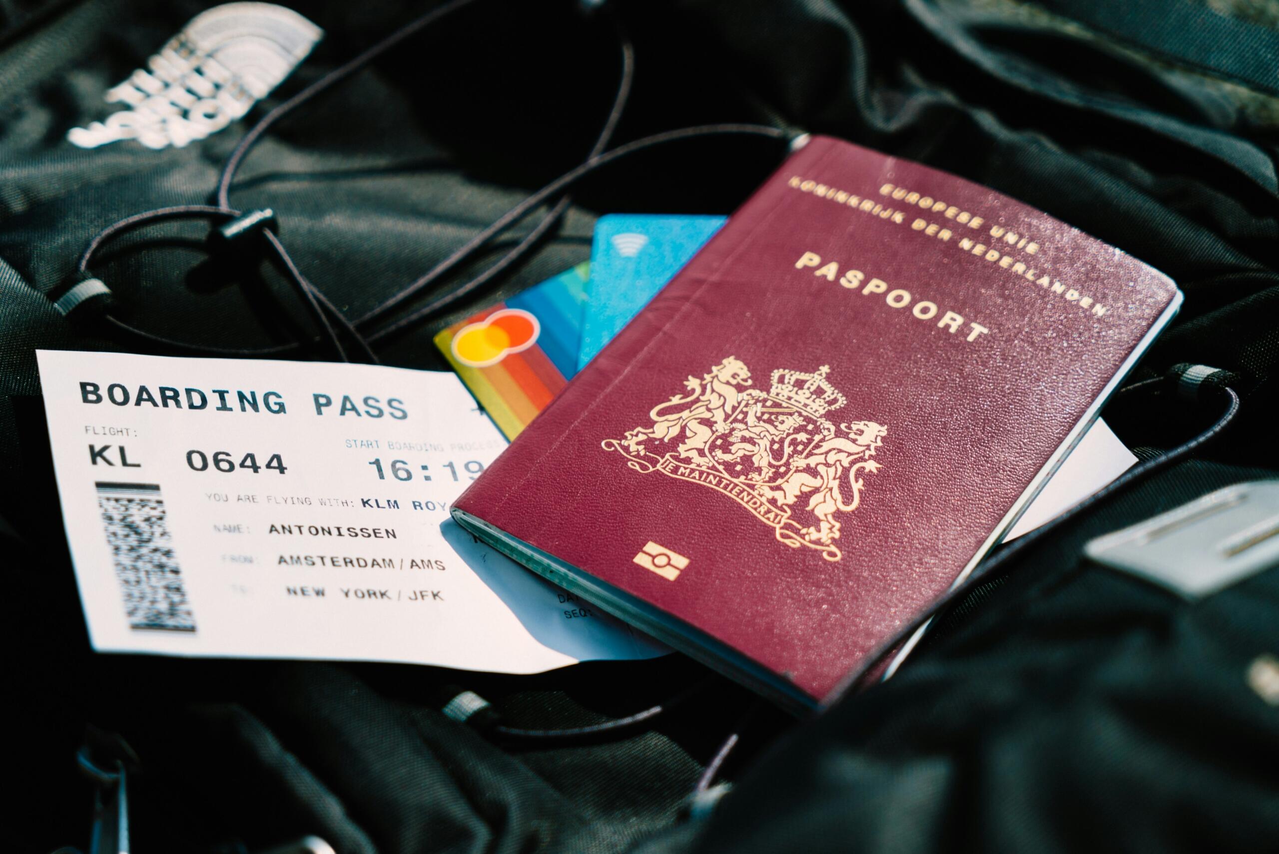 A passport and boarding pass rest on top of a travel bag before departure.