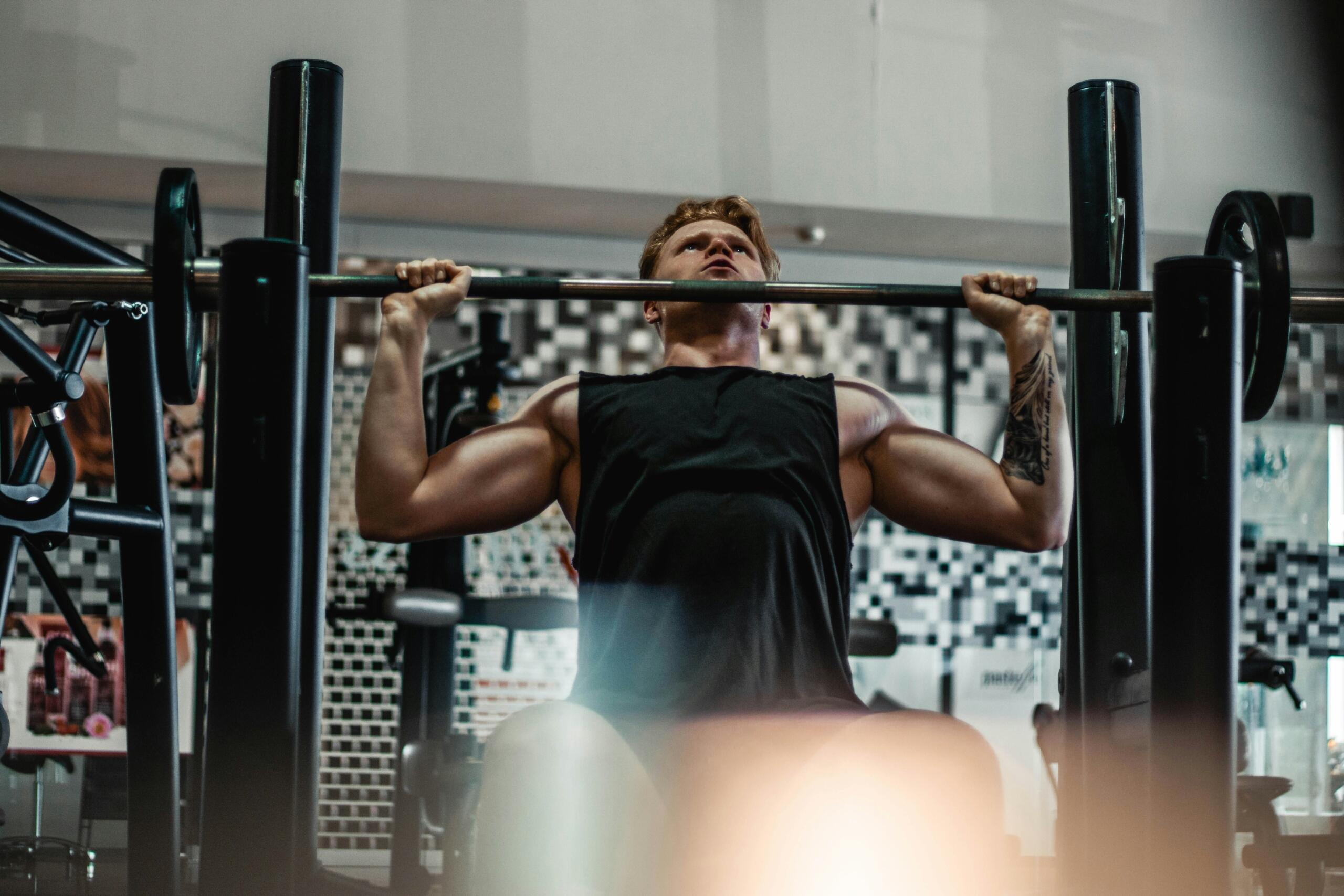 Man performing a shoulder press in a gym