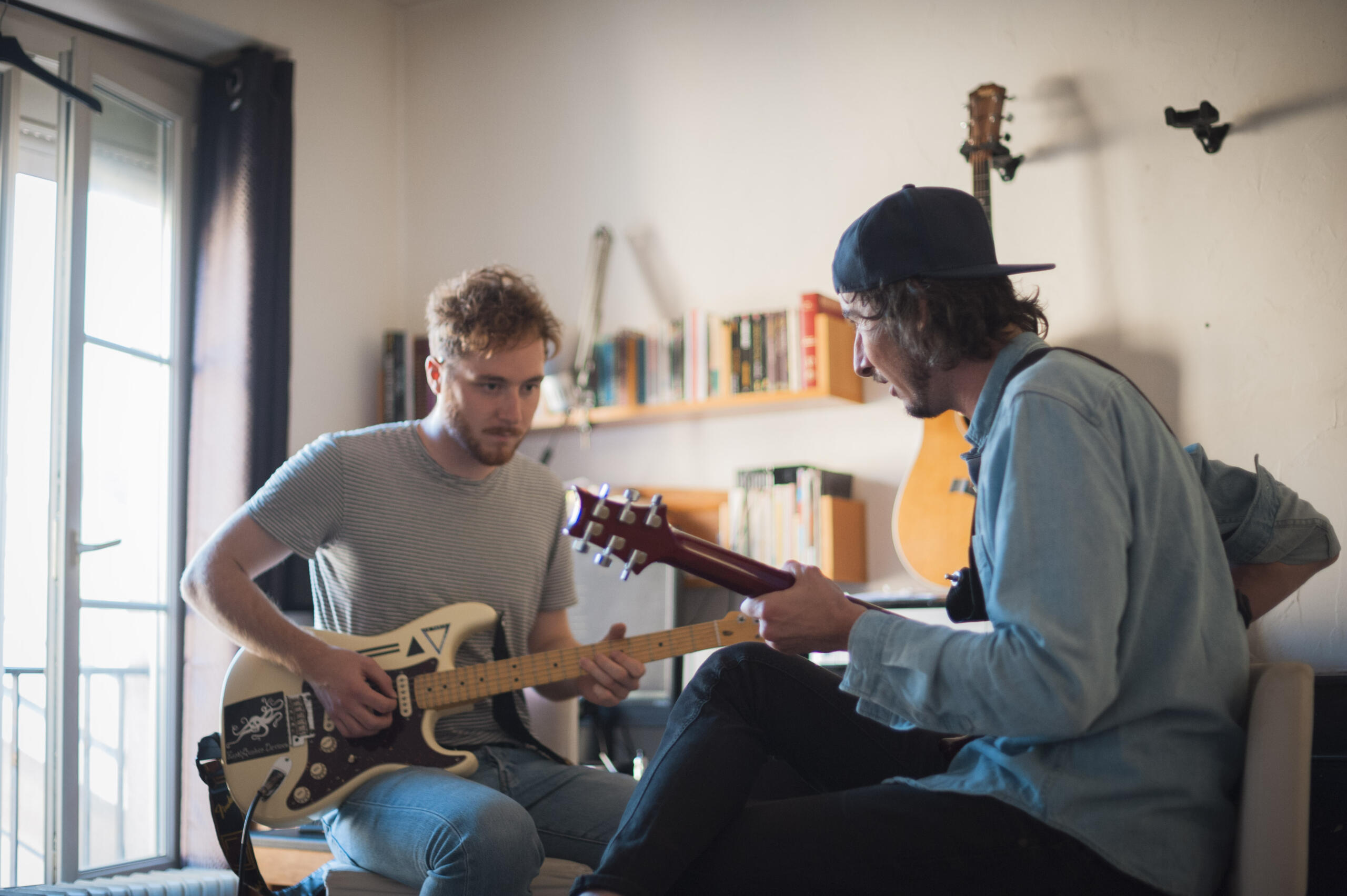 Student learning guitar with a private tutor during an in-person music lesson