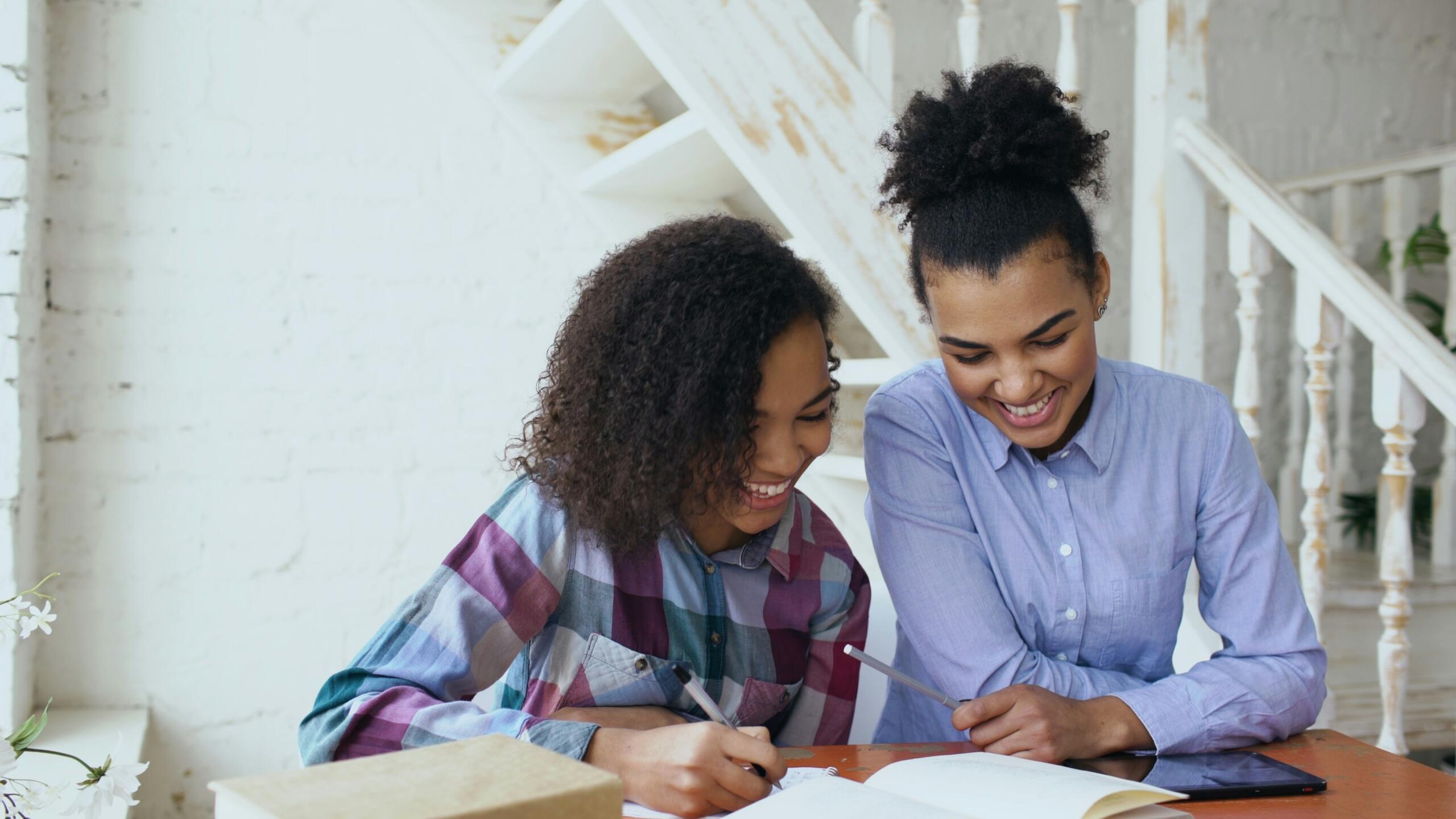 Private tutor helping a student with homework during a one-to-one lesson