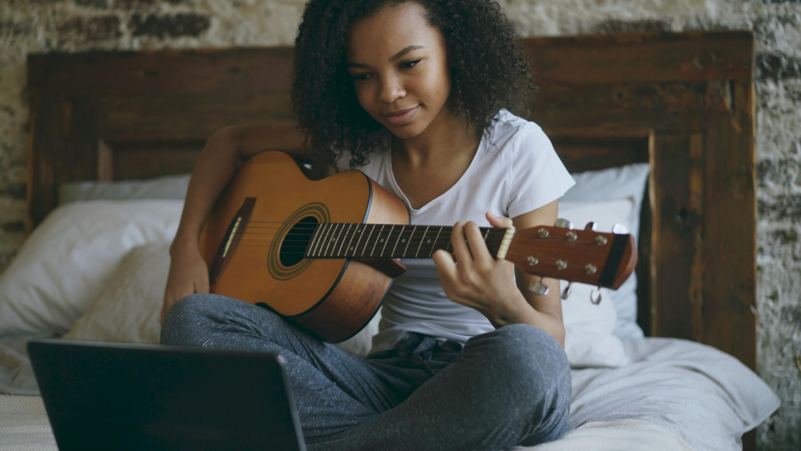 student learning guitar through an online lesson on Superprof