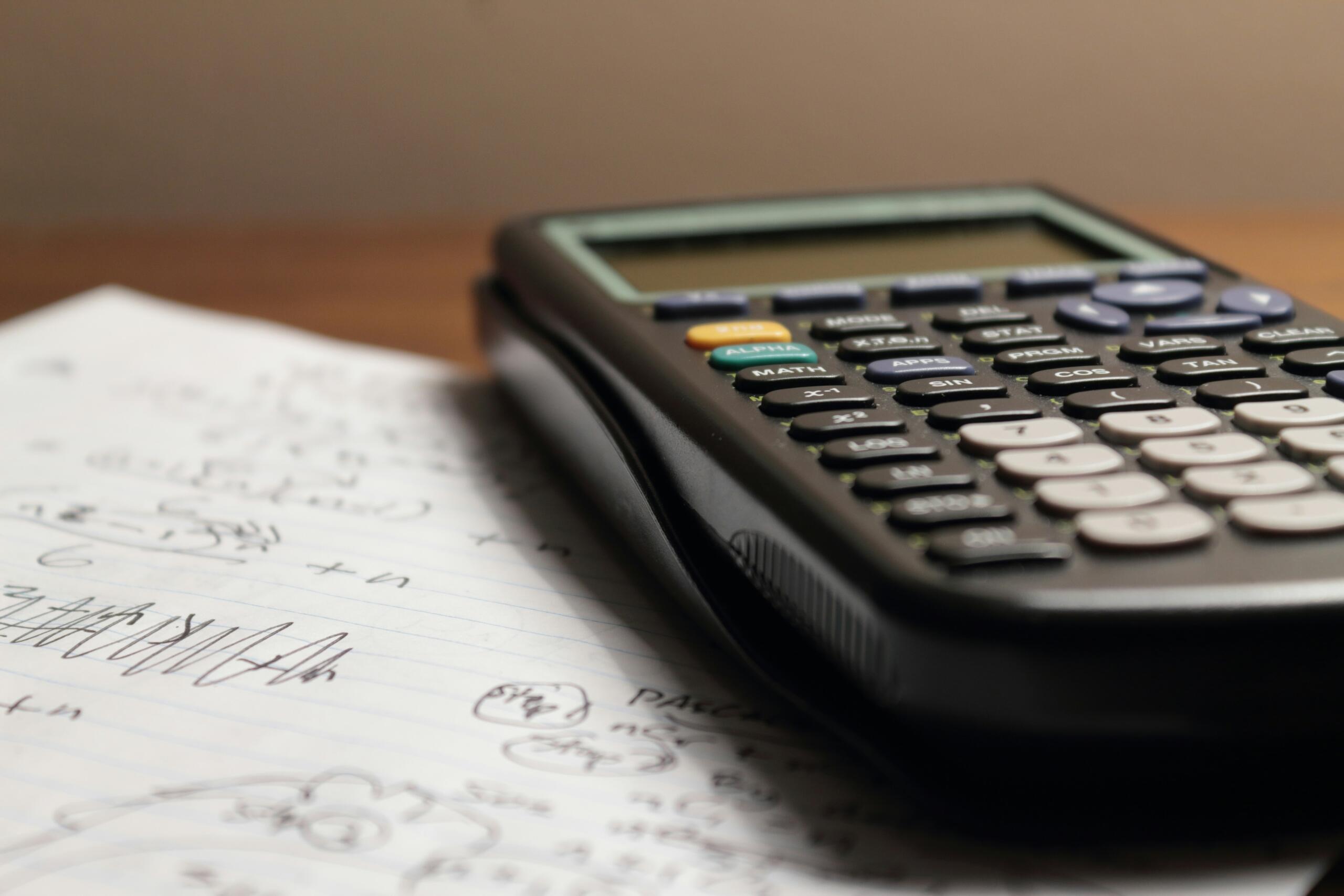 A calculator sits on top of a sheet of paper.