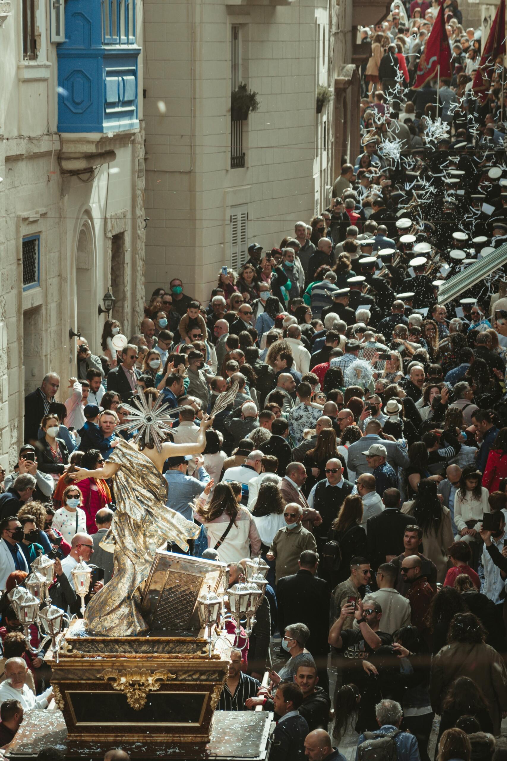 large crowd gathered around the vara during a Maltese festa procession